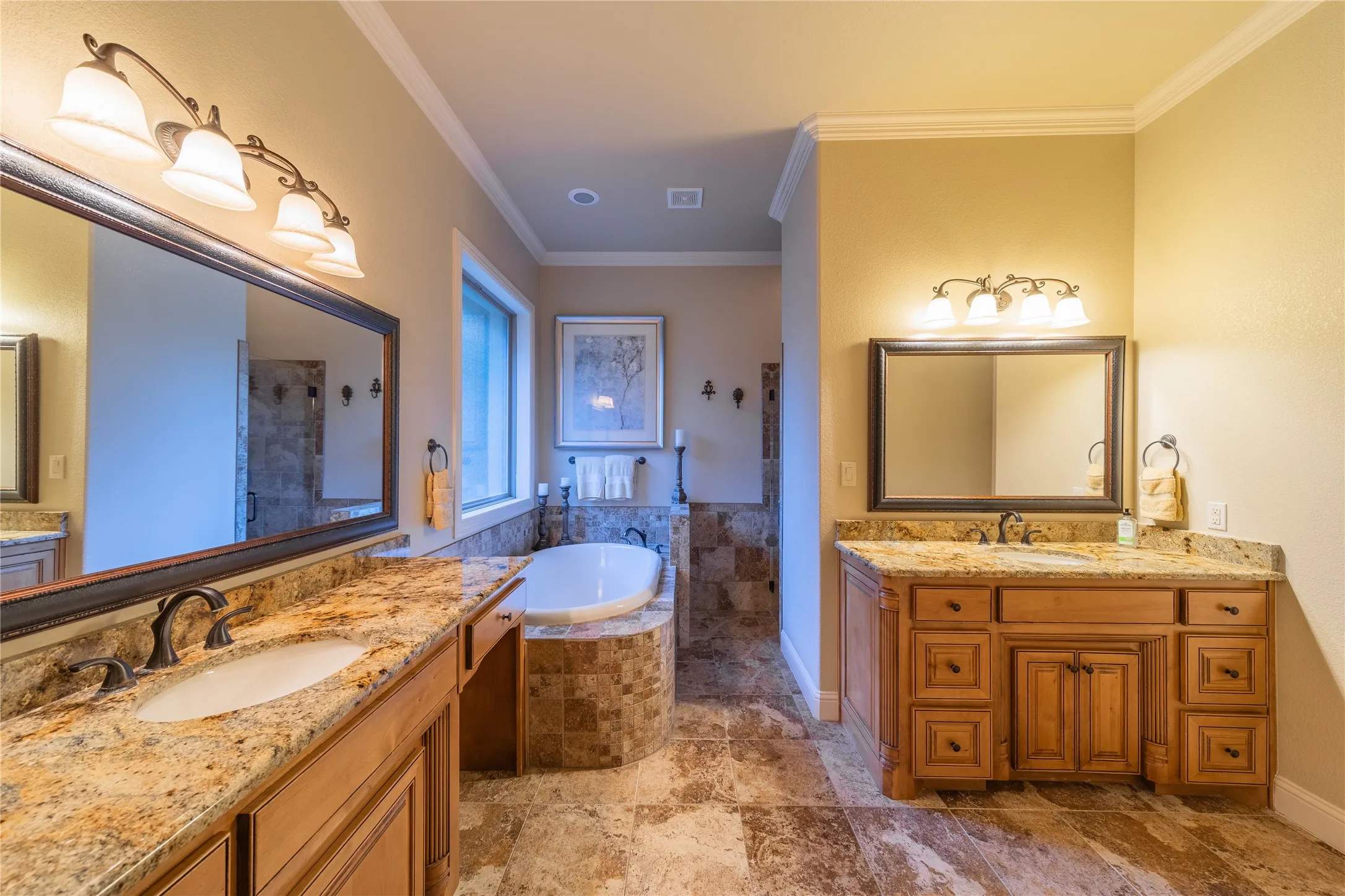 The primary bathroom has dual vanities, a deep soaking tub and a standalone shower located across from the tub.