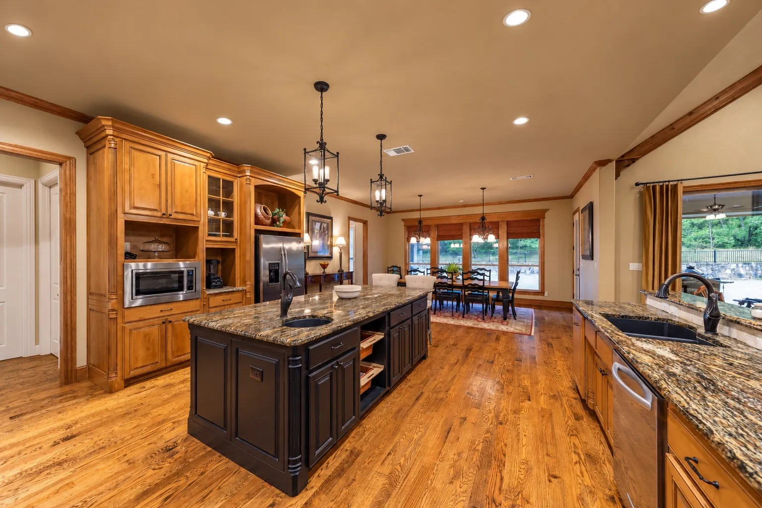 Located in the hallway to the far left in the photo is the walk-in pantry and the utility room with washer, dryer and additional sink.