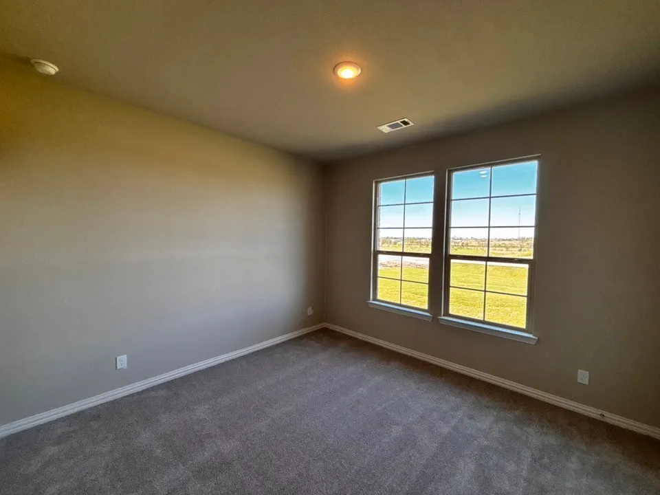 Textured carpeting, neutral wall paint, recessed lighting, and a dual-pane window