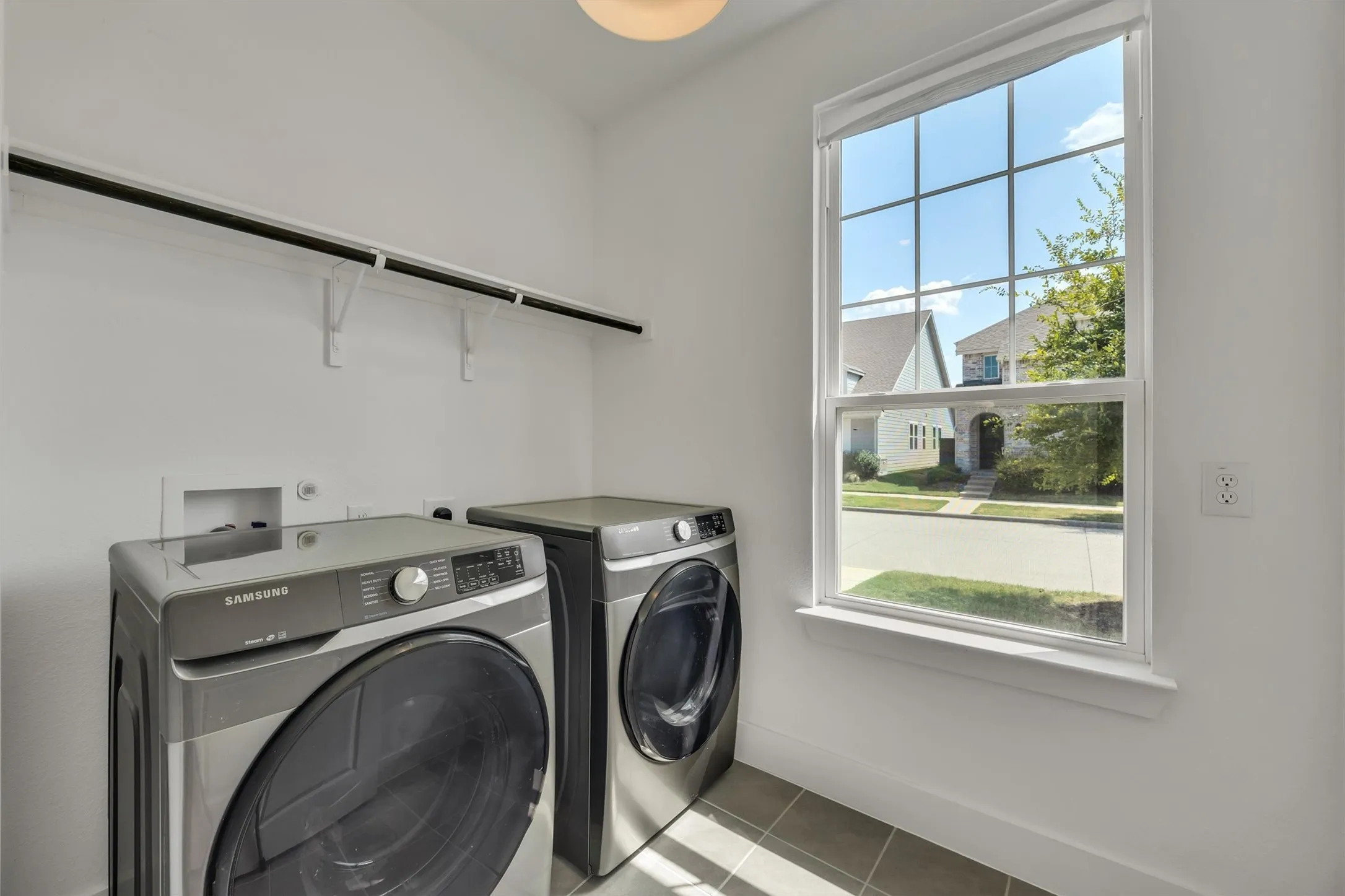 Laundry area with tile flooring and a window