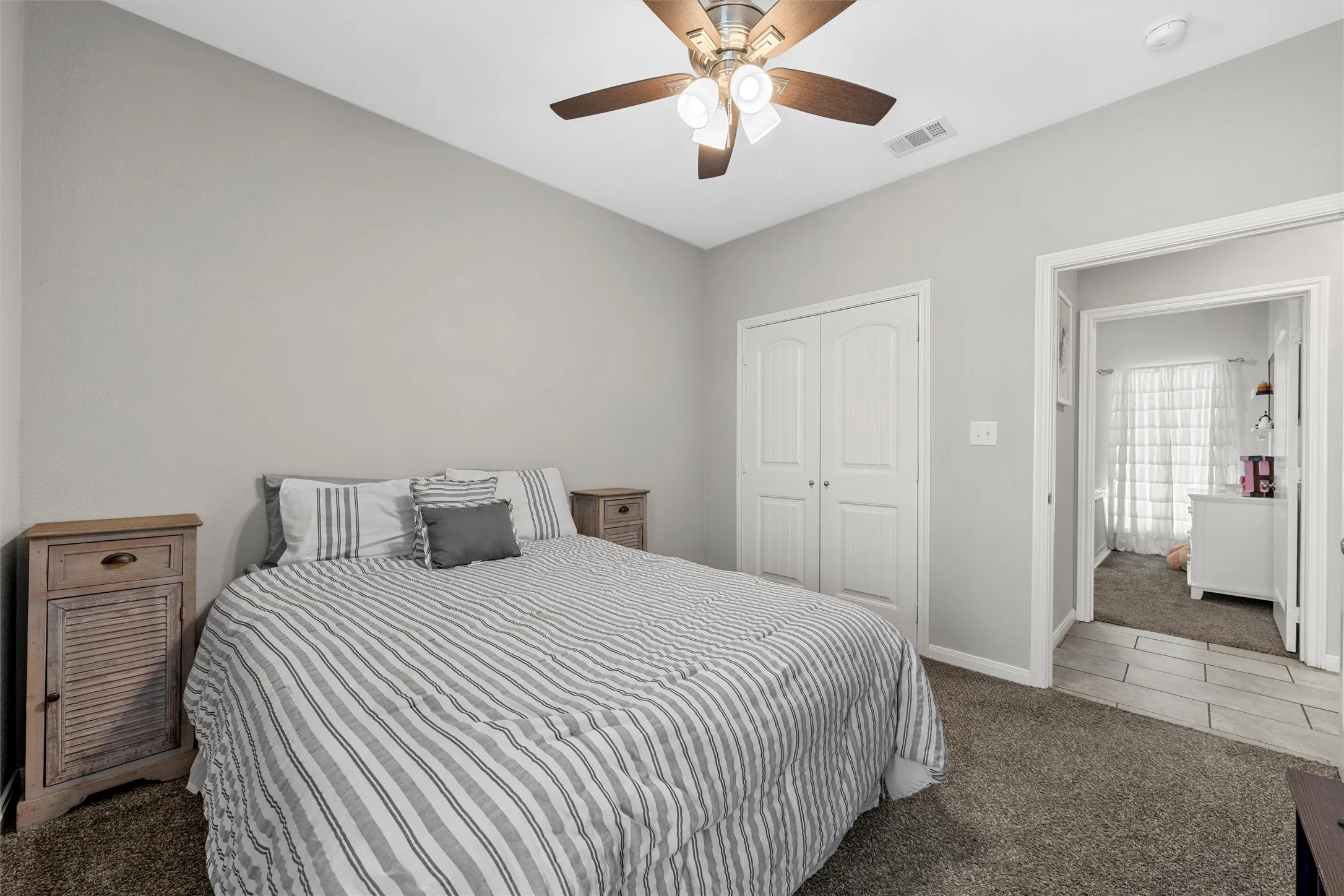 Recessed ceiling fan, light gray wall paint, white bi-fold closet doors, and dark gray carpet flooring