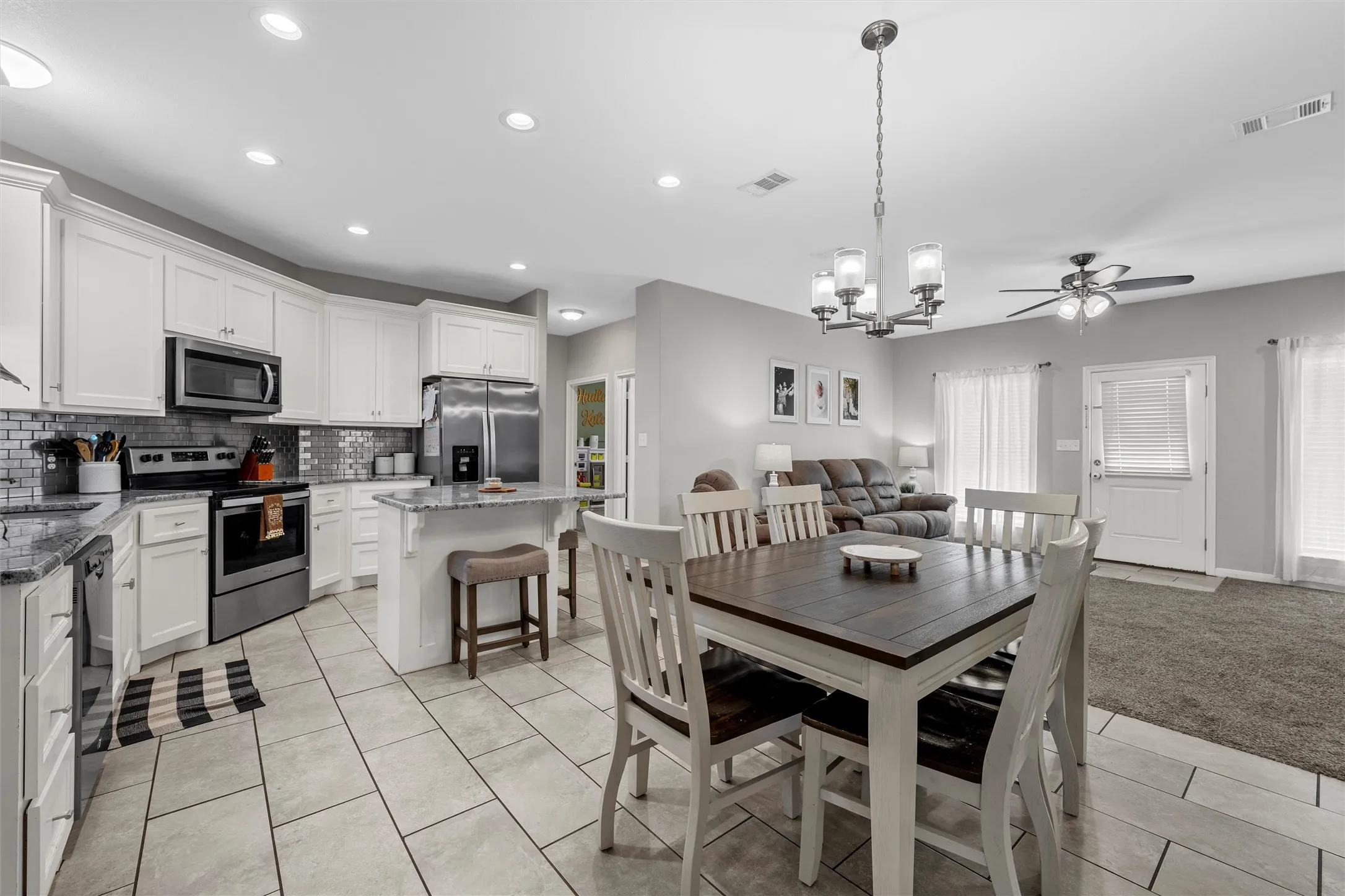 Kitchen with white cabinetry, stainless steel appliances, and a tiled backsplash