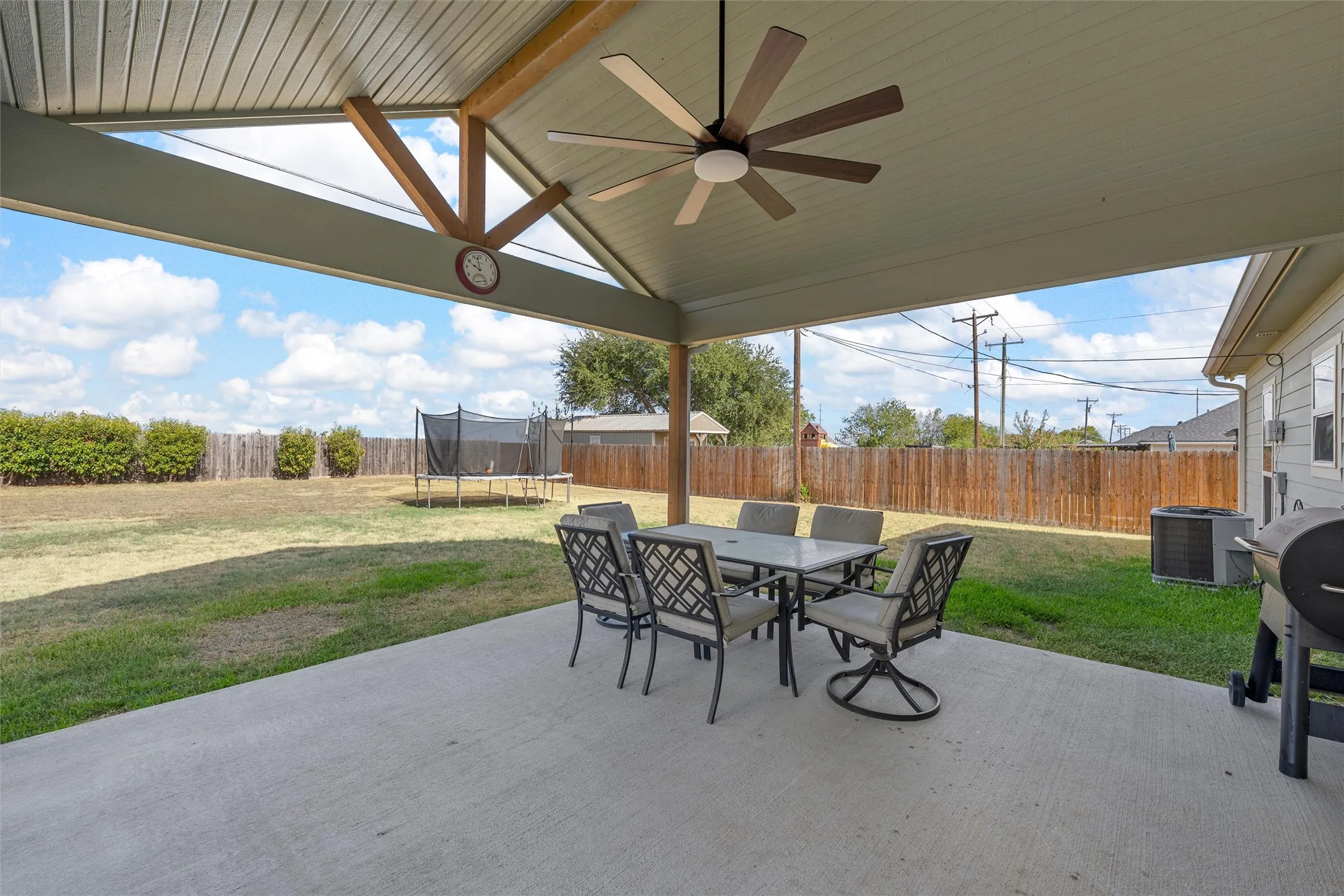 Expansive concrete patio with a vaulted ceiling and exposed wood beams
