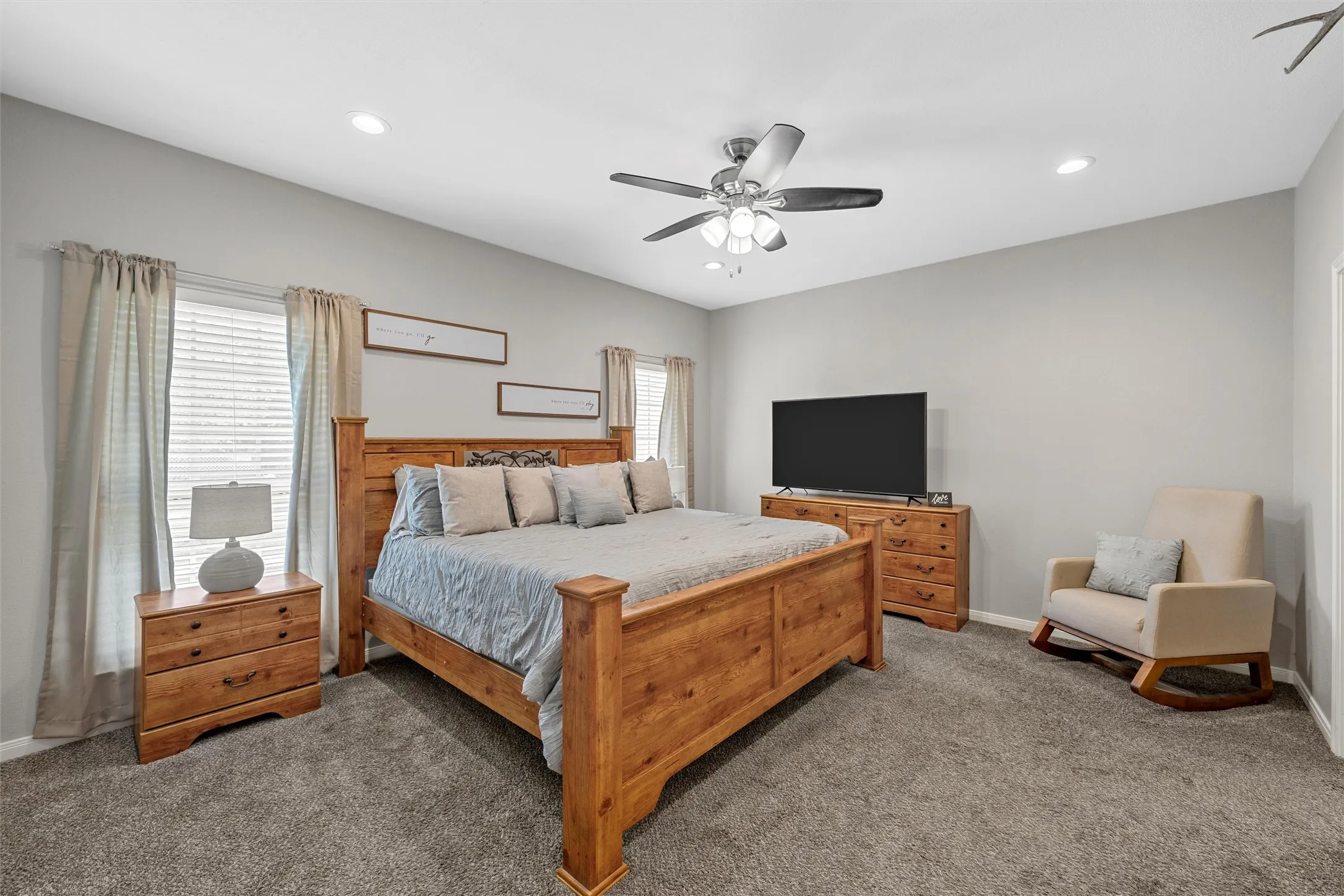 Plush gray carpeting, light gray wall paint, recessed lighting, and a ceiling fan with light fixture
