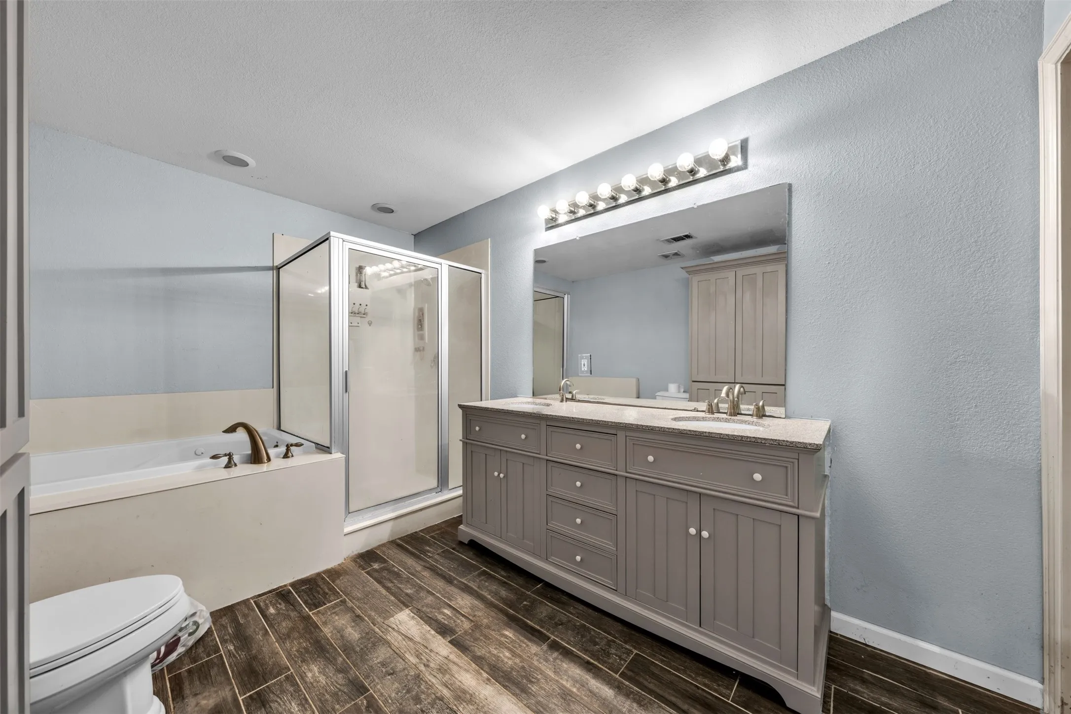 Double vanity with integrated sinks, granite countertop, and expansive mirror