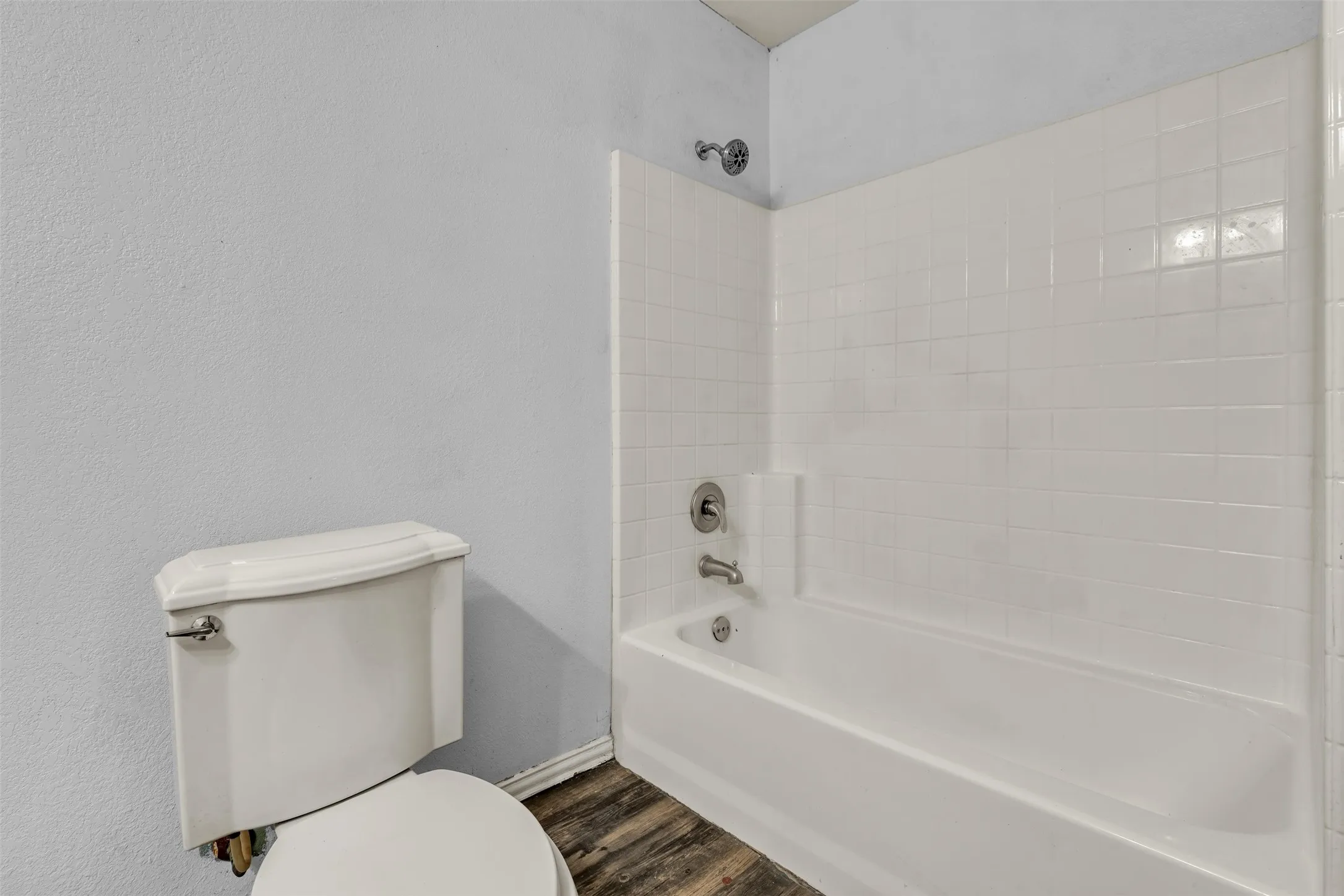White subway tile shower surround with integrated bathtub and chrome fixtures