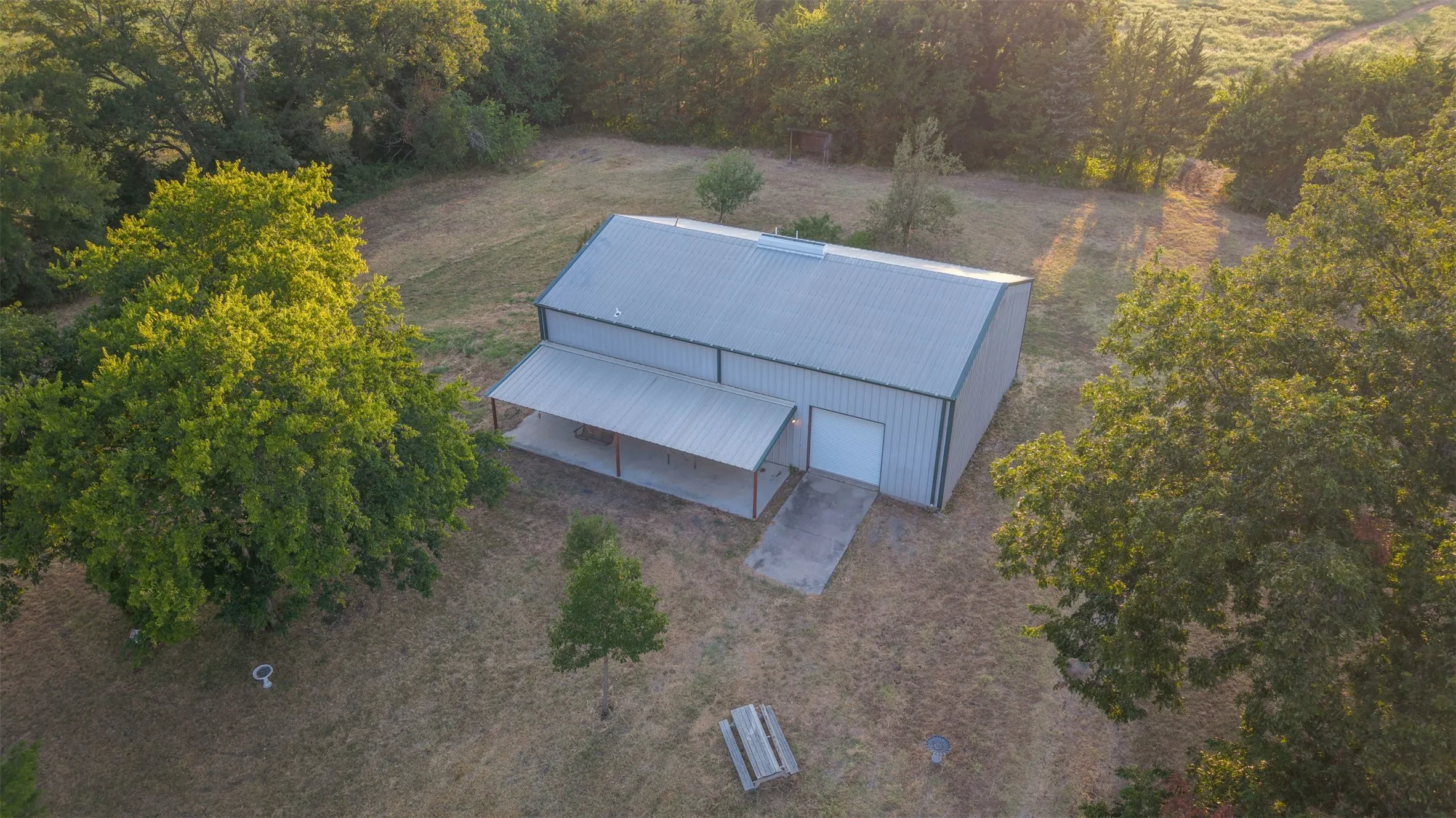 Metal-sided structure with a gabled roof and covered concrete porch