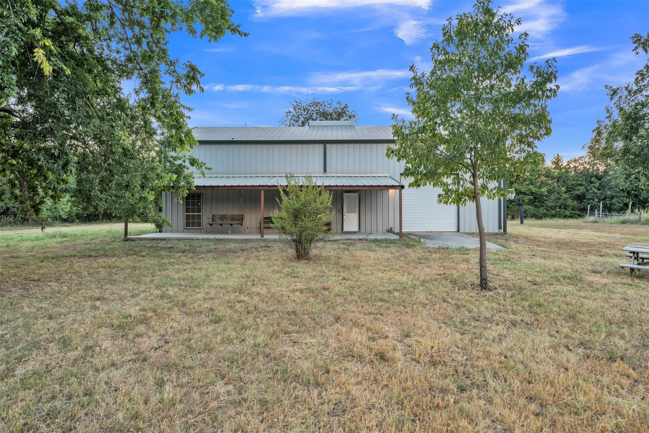 Metal-sided structure with a covered front porch and a roll-up garage door