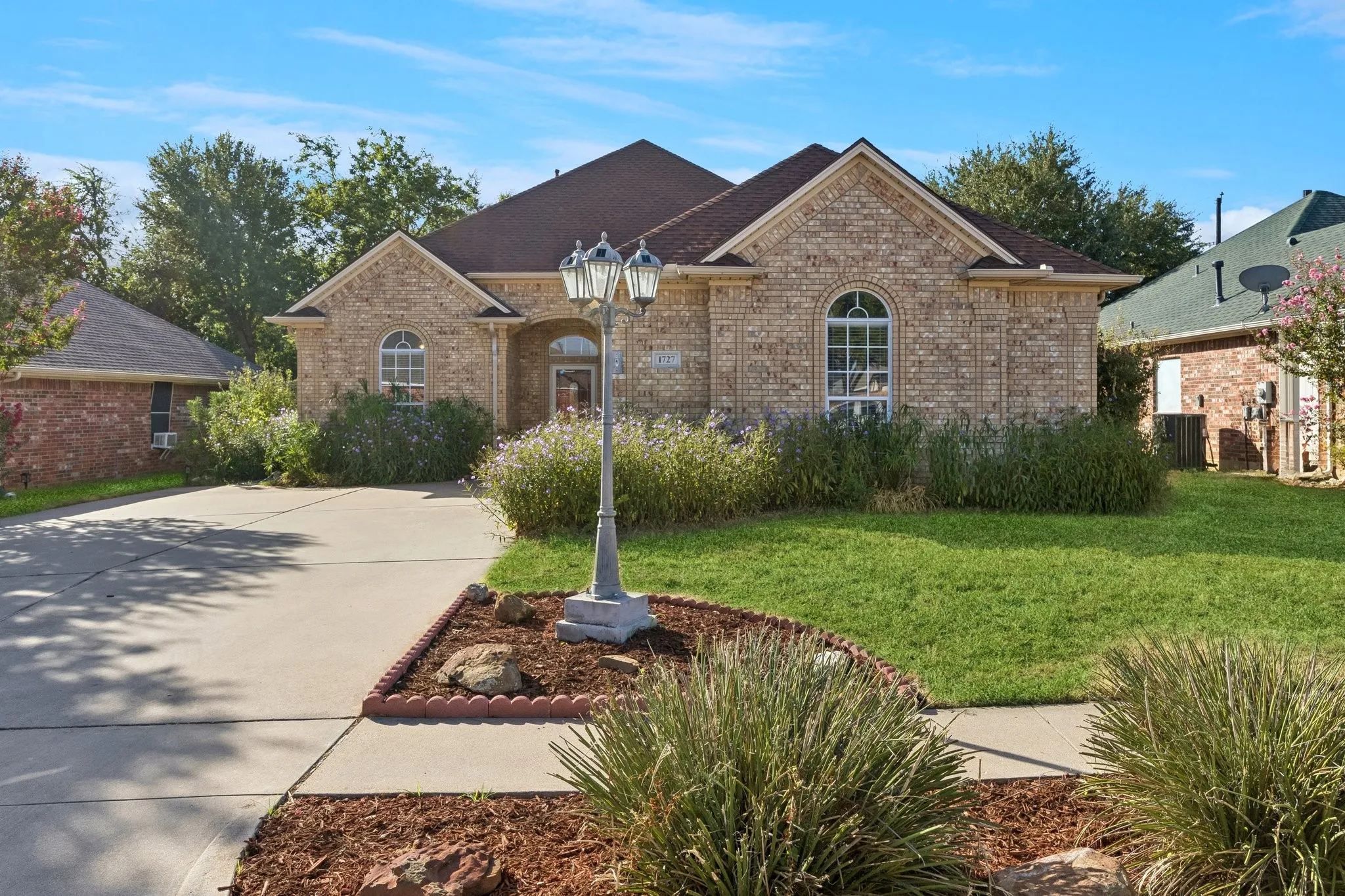 Front of home, a gabled roofline, a front lawn, and landscaped garden beds