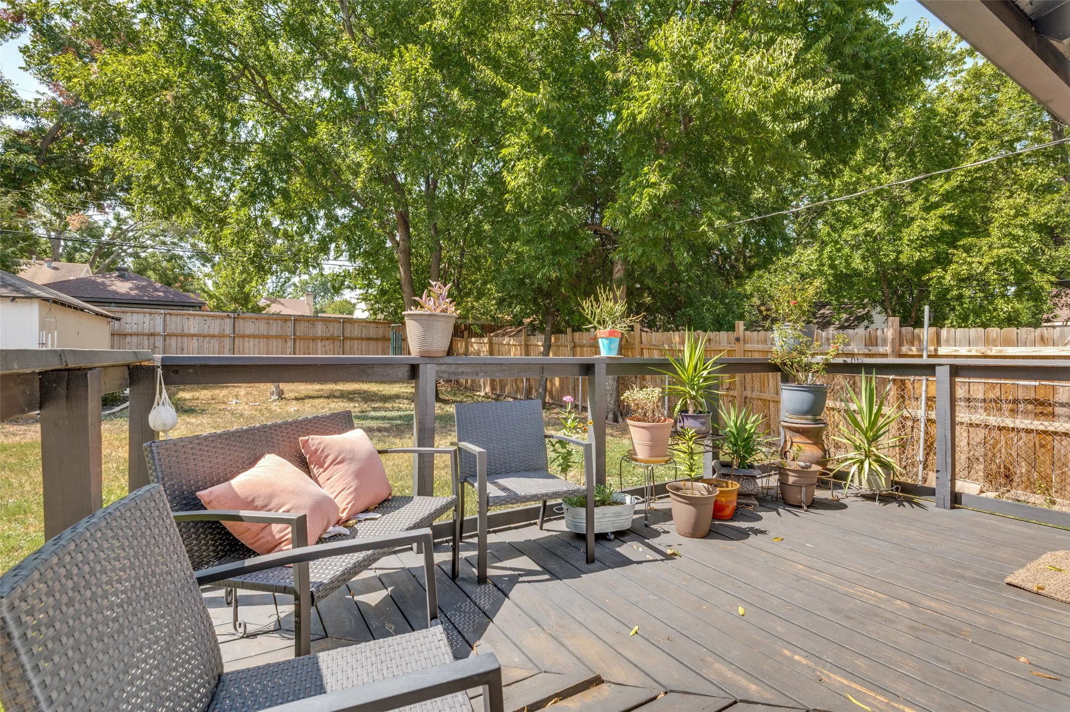 Expansive outdoor deck with dark wood-finish flooring and a wood railing