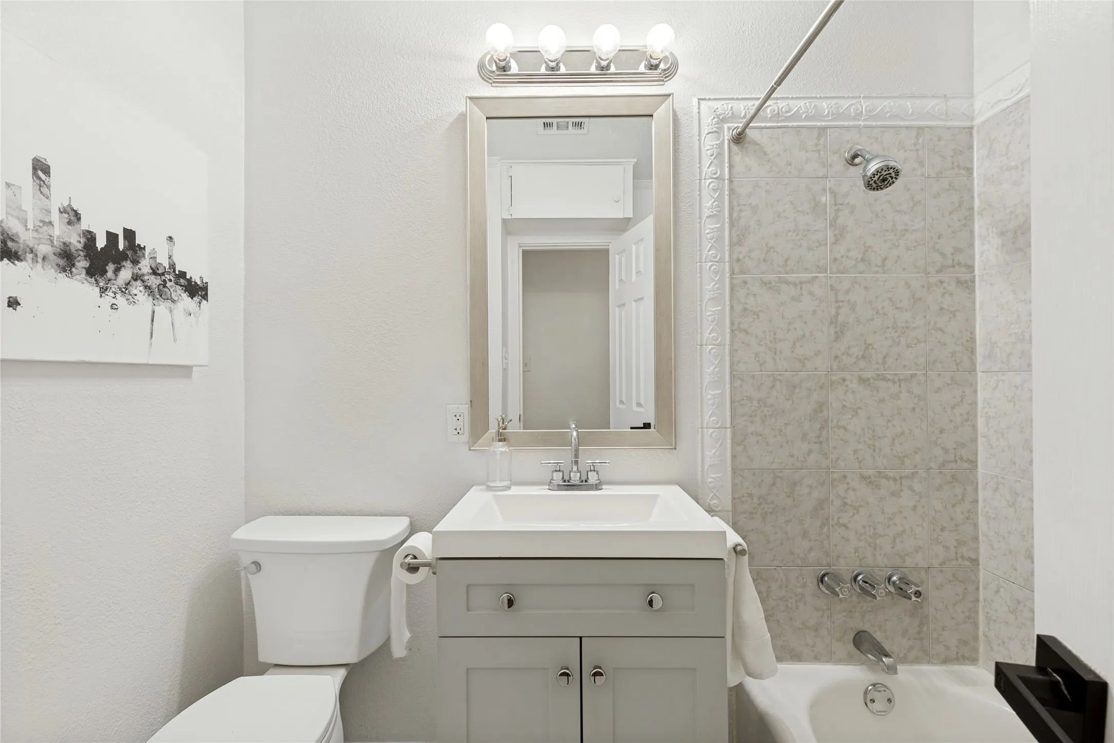 Integrated vanity with a single basin sink, light gray cabinetry, and brushed nickel hardware