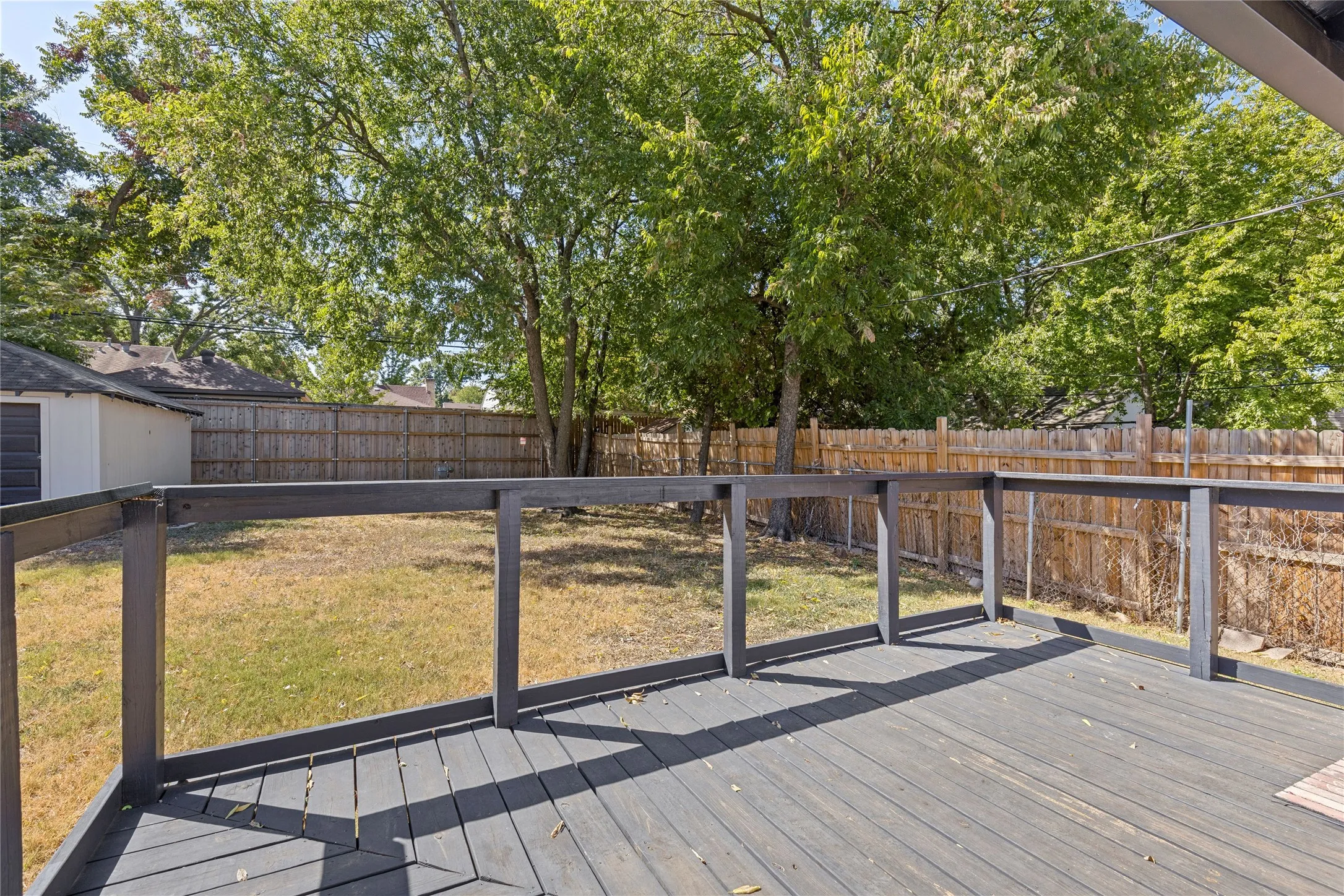 Spacious wood deck with dark grey finish and matching railings