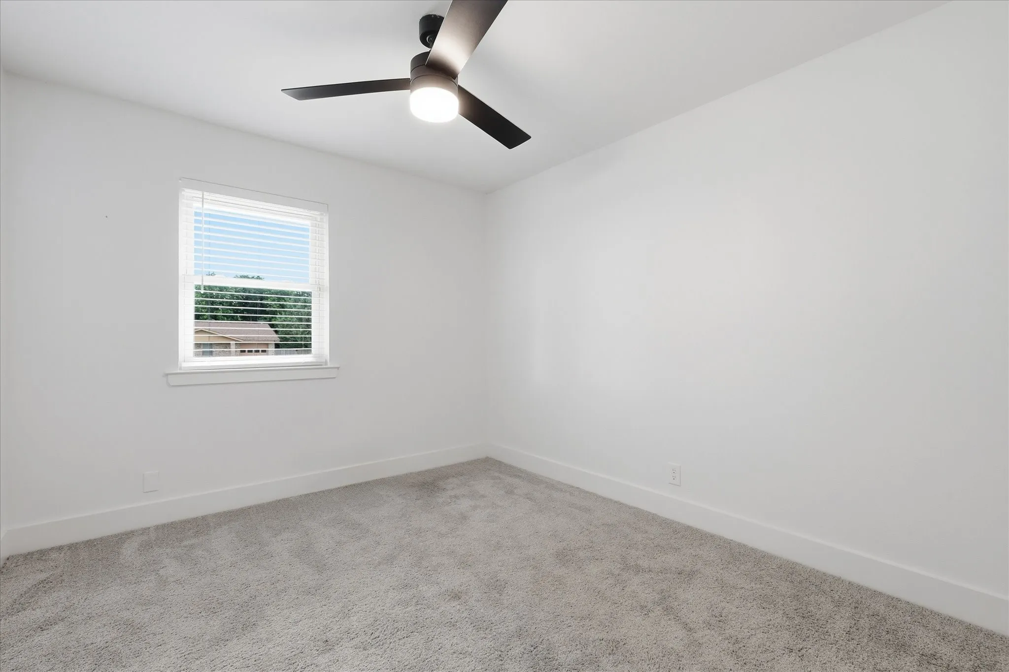 Recessed lighting and a ceiling fan fixture complement light gray carpeting