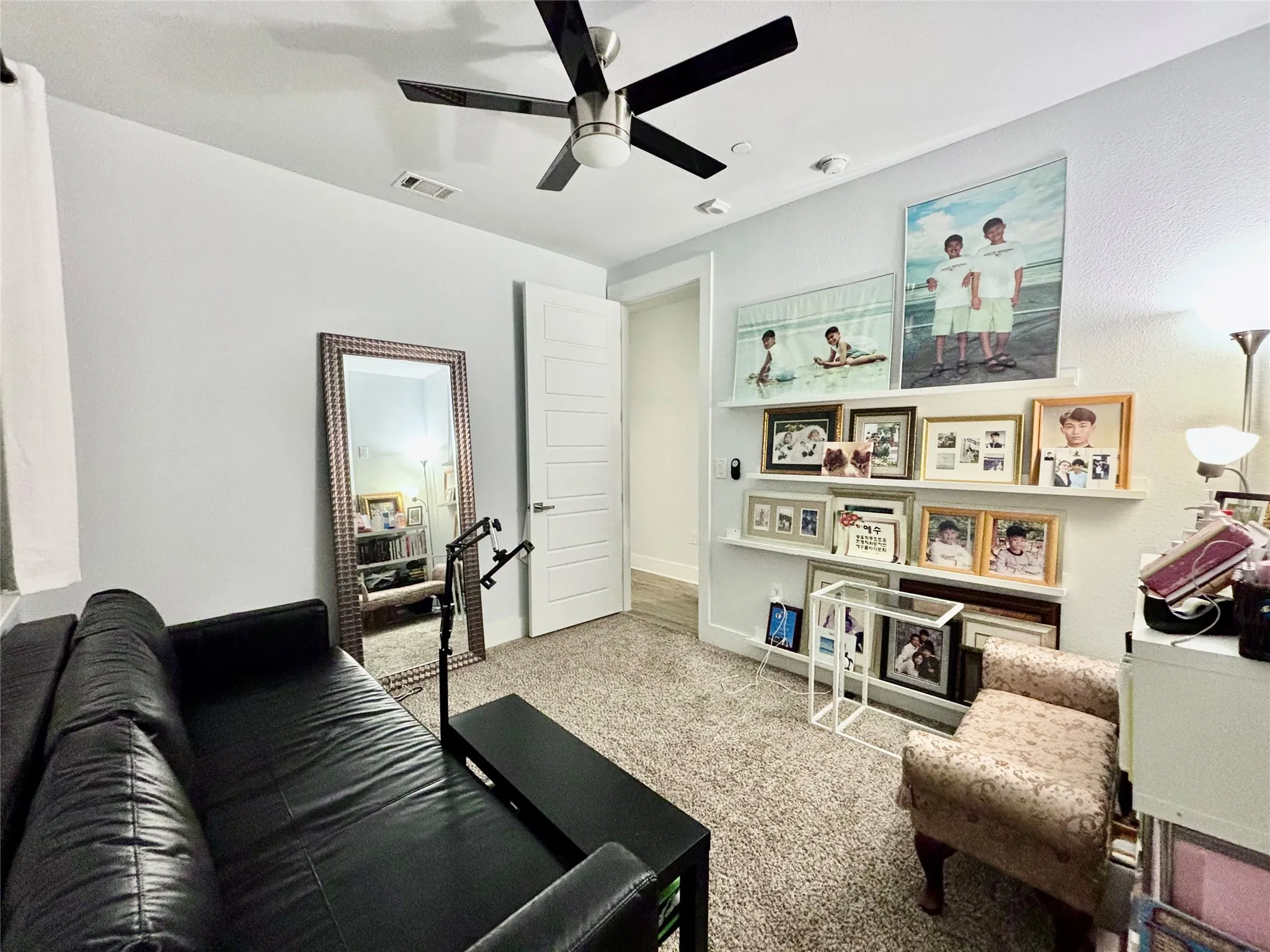 Recessed lighting fixtures, ceiling fan with black blades, white interior door, and light gray wall paint