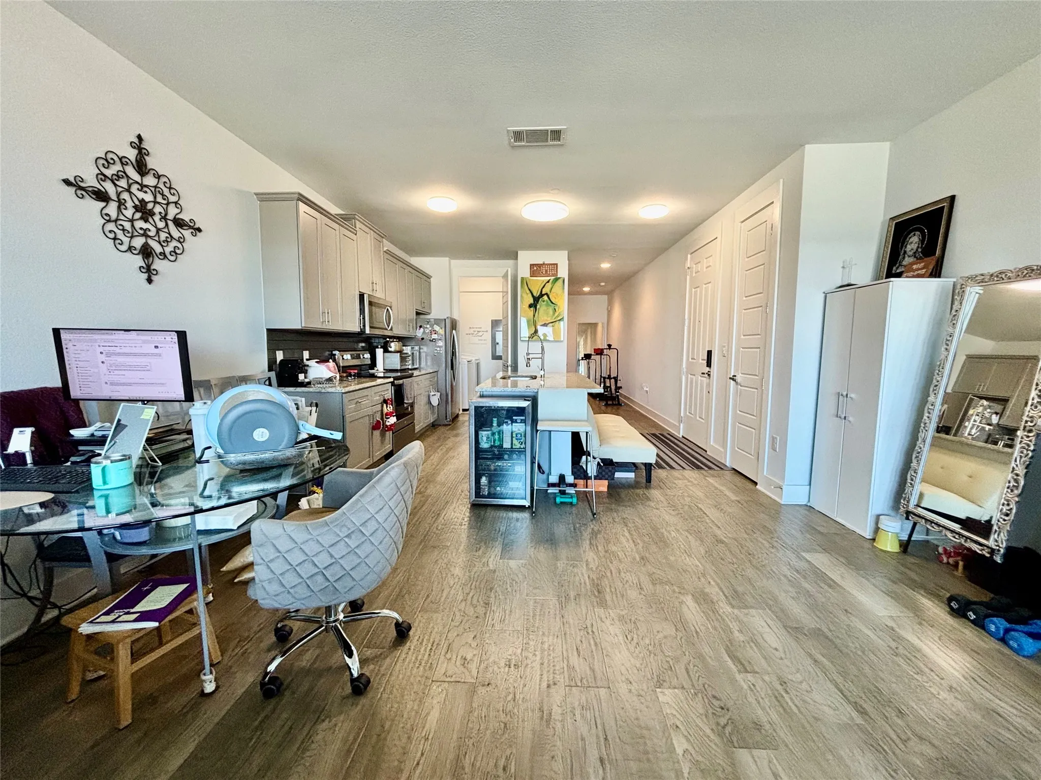 Open-concept living space with wood-finish flooring, vaulted ceiling, and recessed lighting