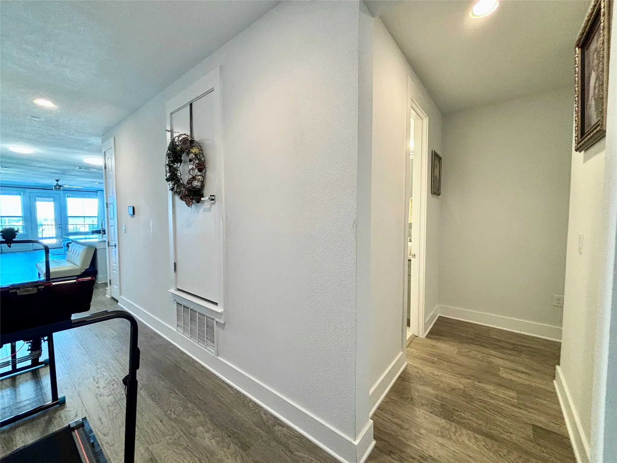 Recessed lighting illuminates wood-finish flooring