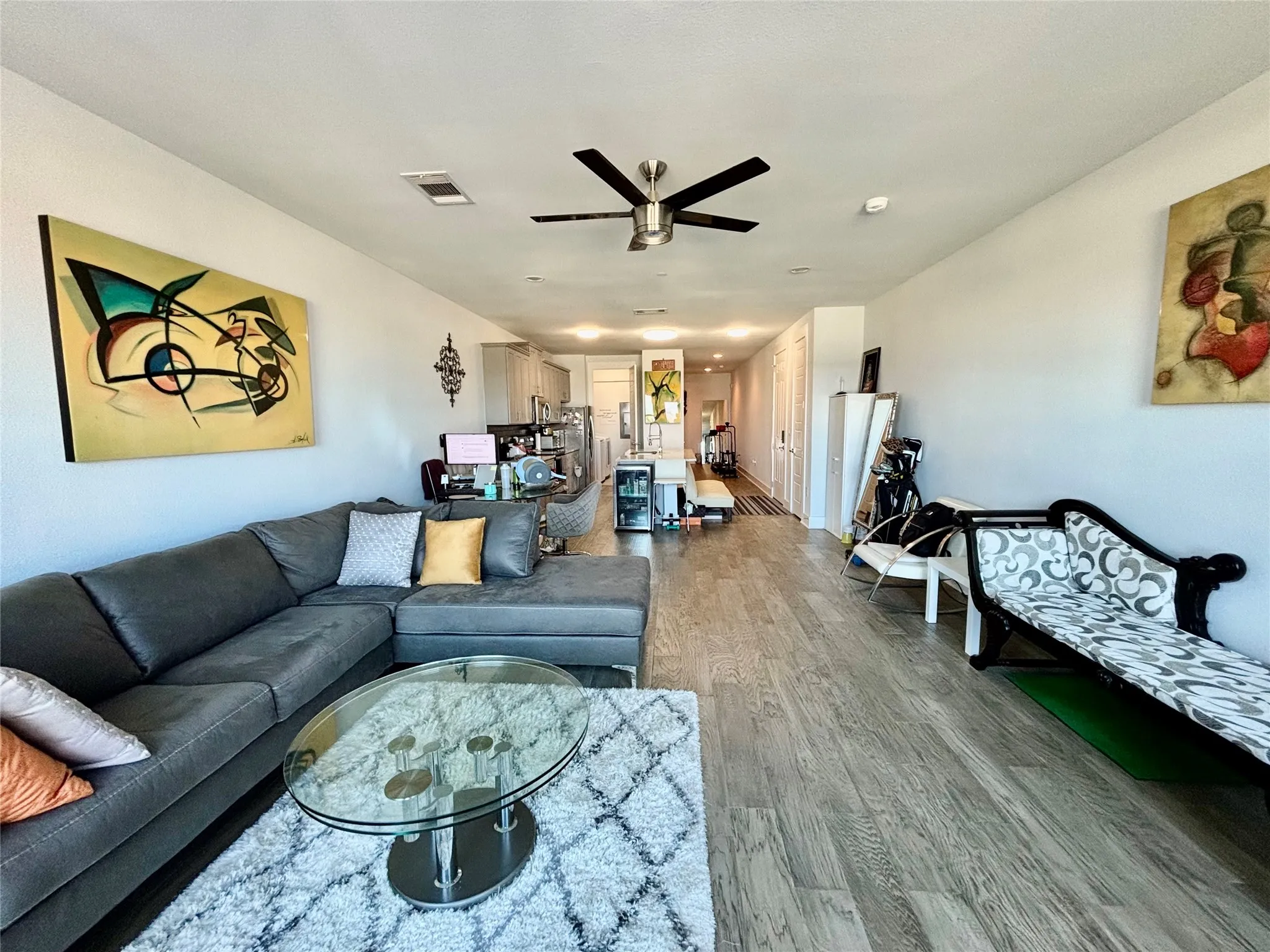 Wood-finish flooring, recessed lighting, and a ceiling fan with integrated lighting