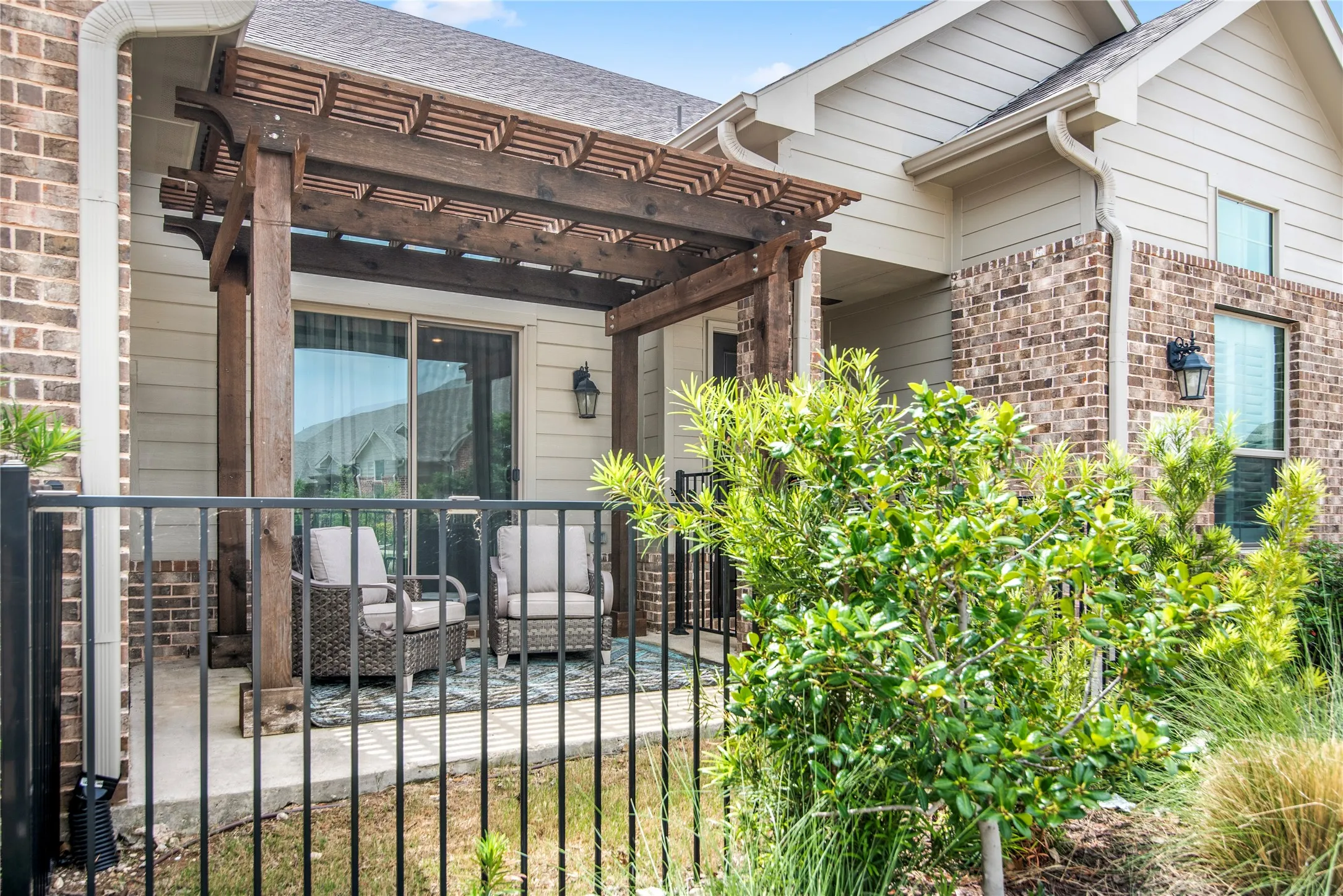 Private patio with a wood pergola, concrete flooring, and sliding glass door access