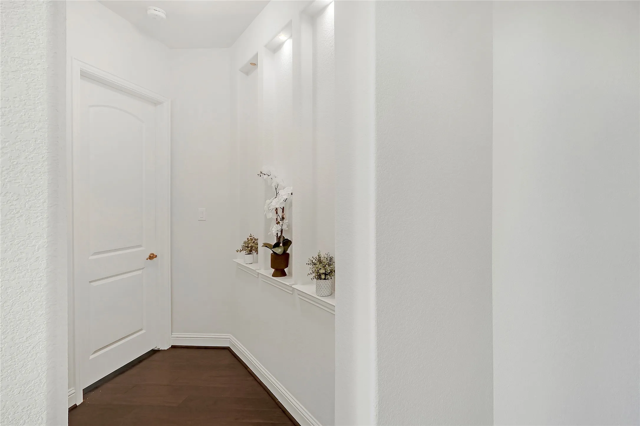 Hall with dark wood-style flooring and baseboards