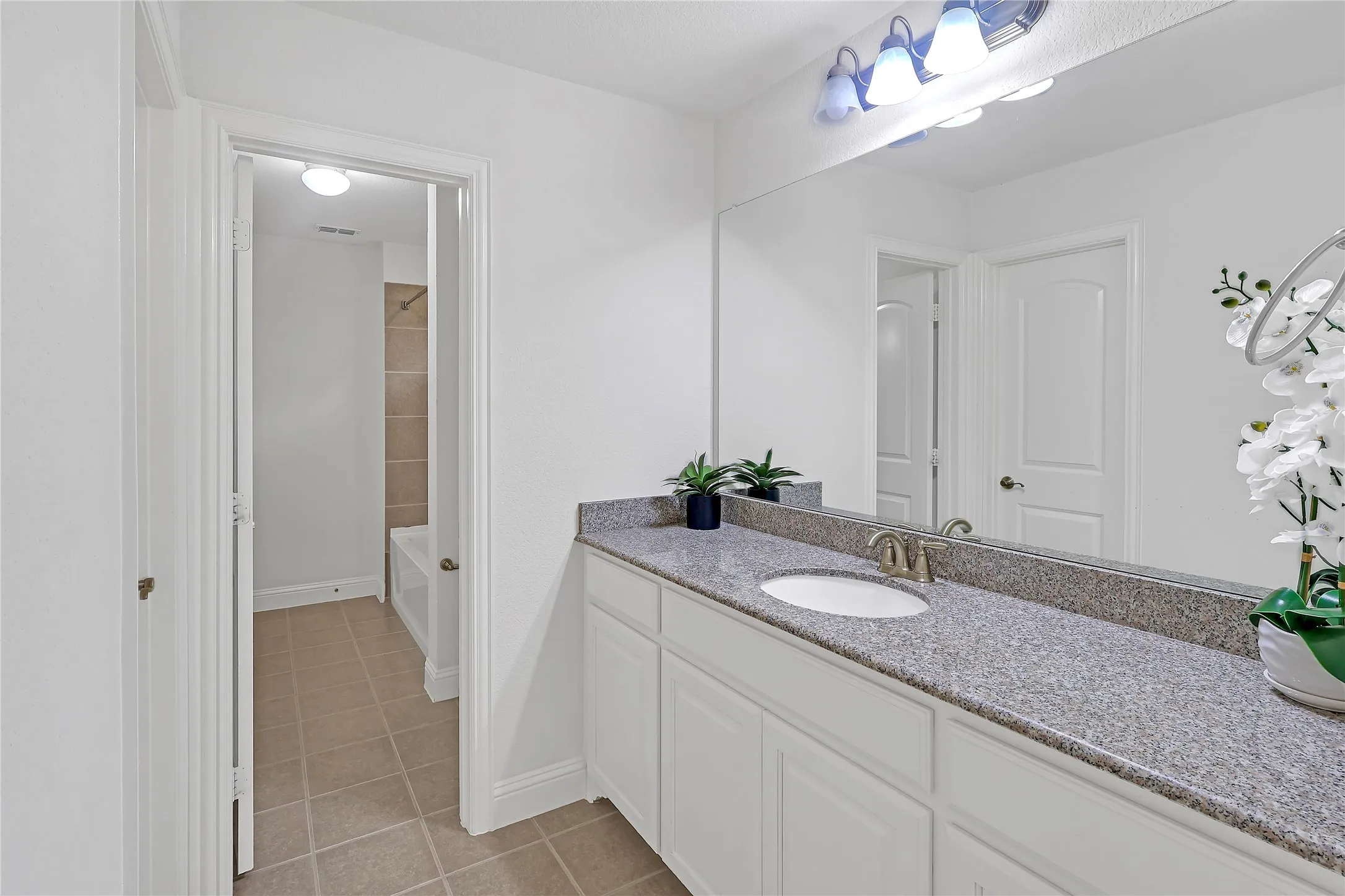 Full bath with tile patterned floors and vanity