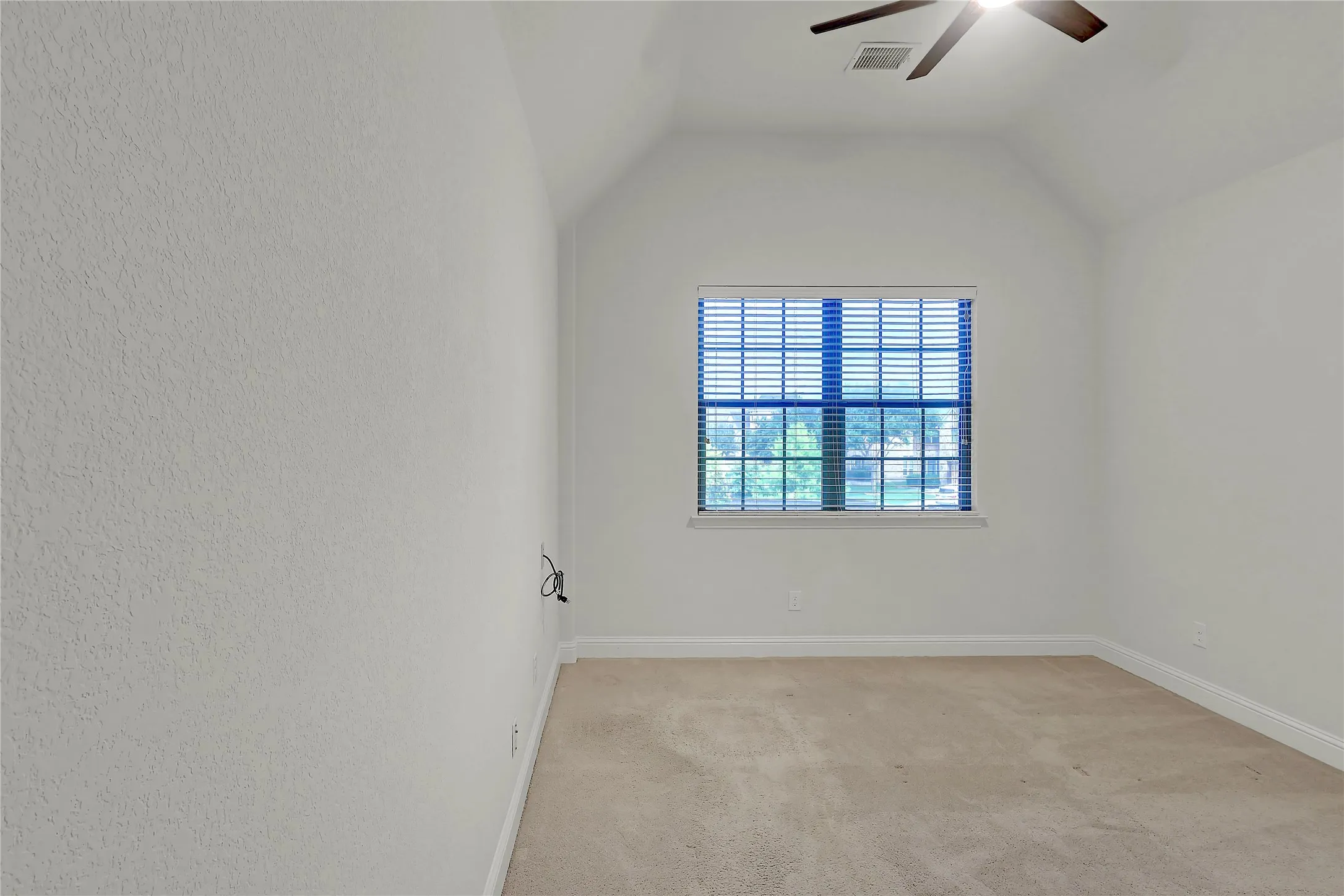 Spare room with a ceiling fan, light colored carpet, and lofted ceiling