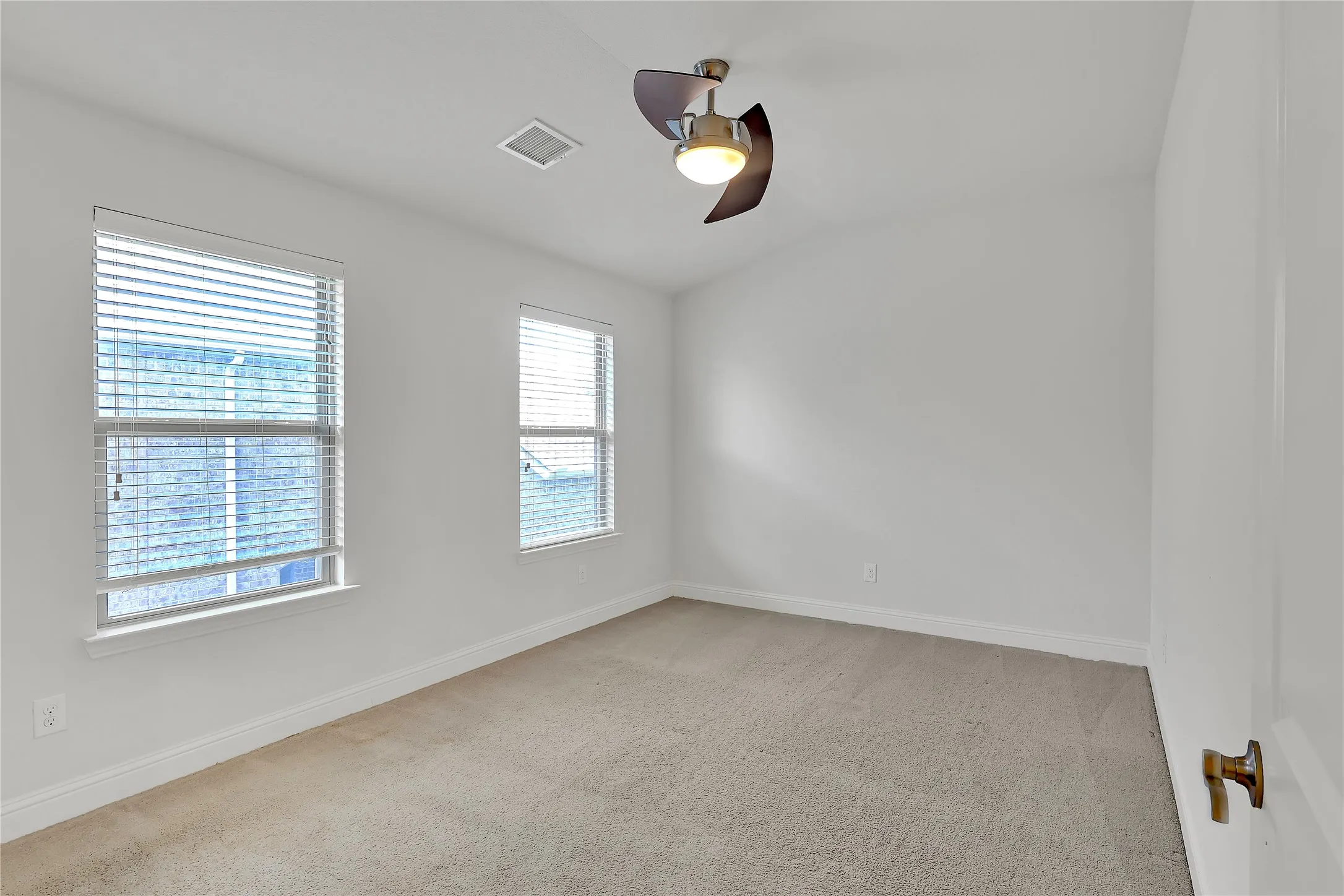 Spare room with a ceiling fan, healthy amount of natural light, carpet flooring, and vaulted ceiling