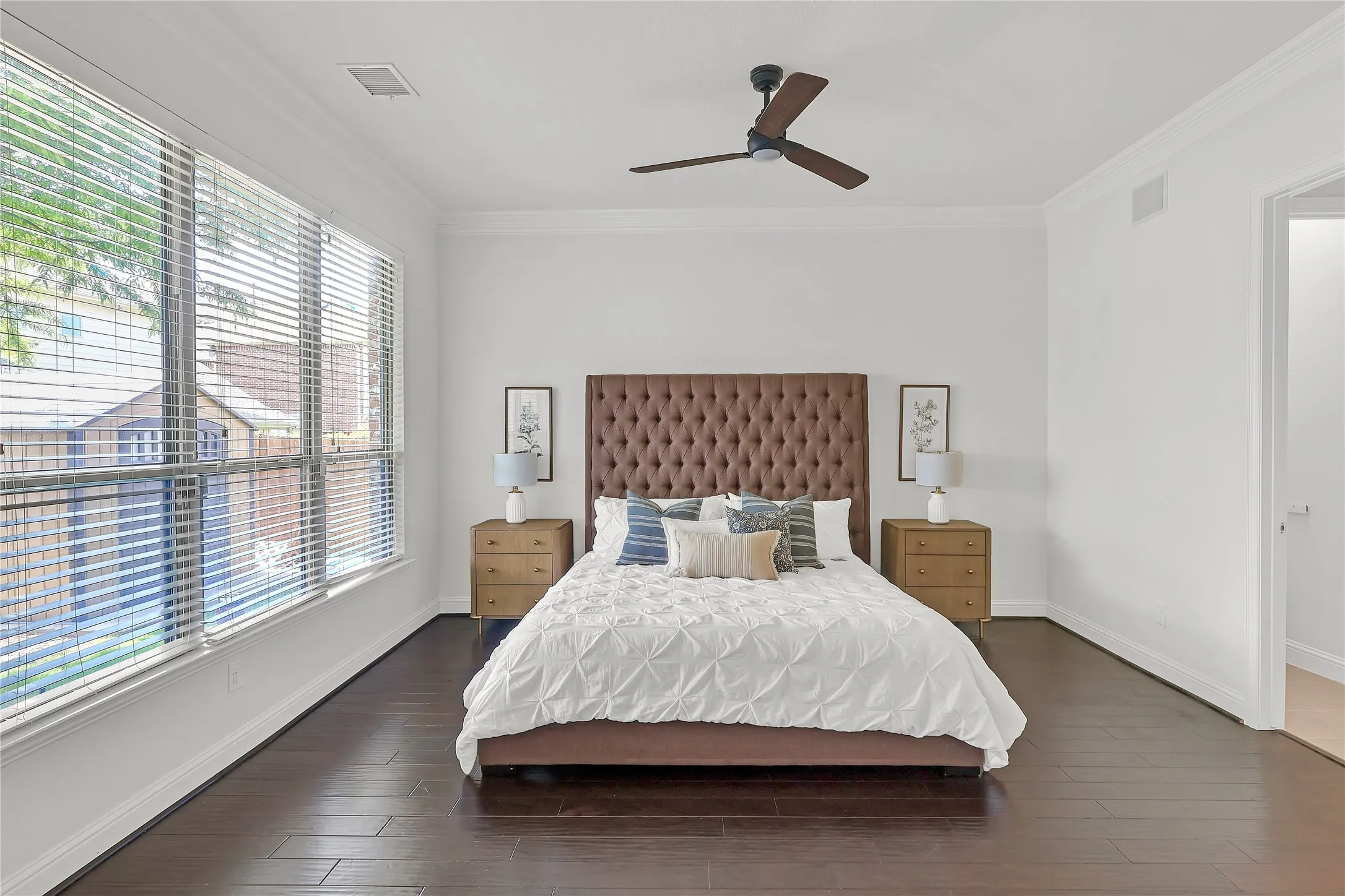 Bedroom with multiple windows, crown molding, dark wood-type flooring, and ceiling fan