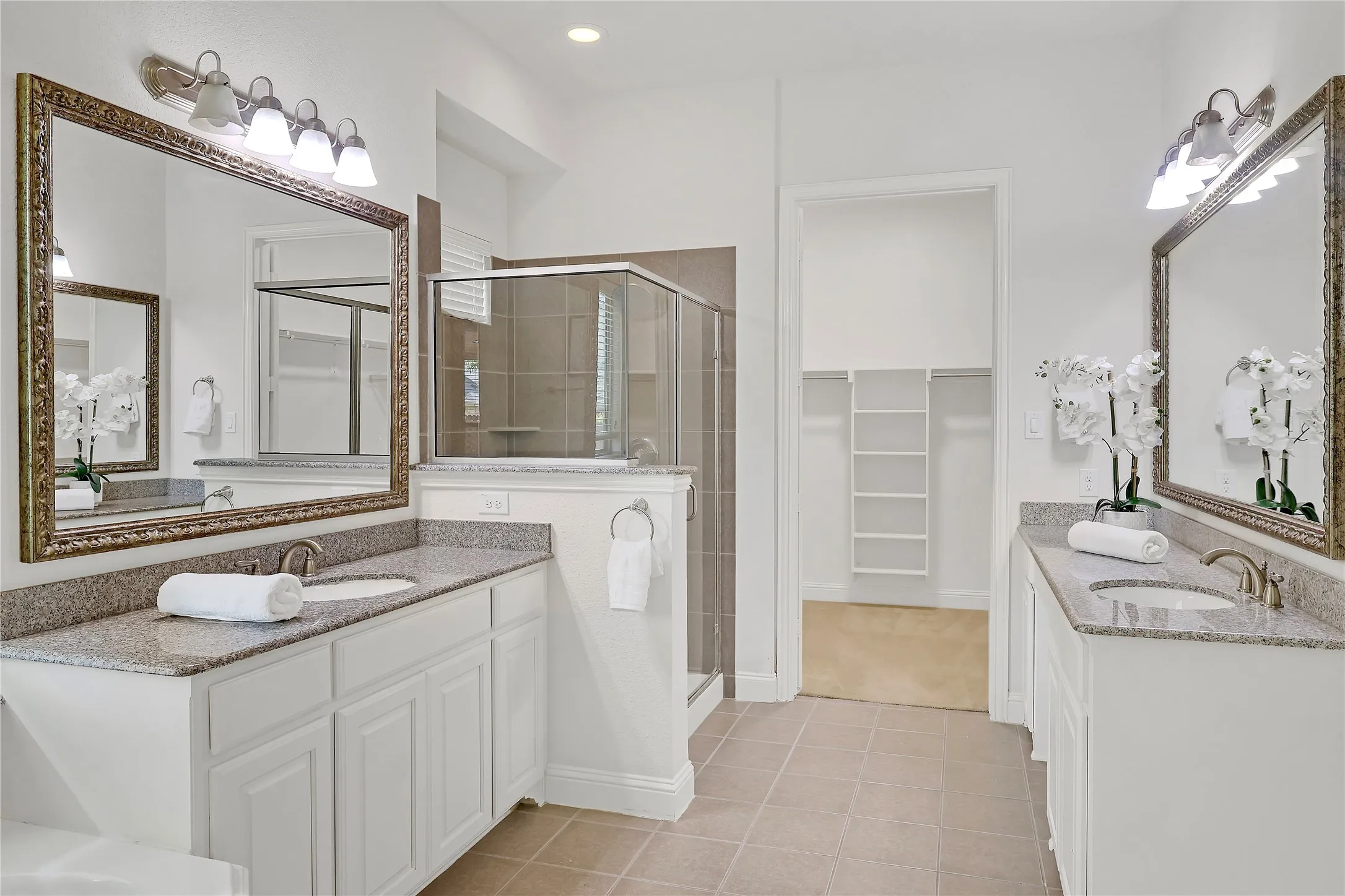 Bathroom with a stall shower, a spacious closet, double vanity, tile patterned floors, and recessed lighting