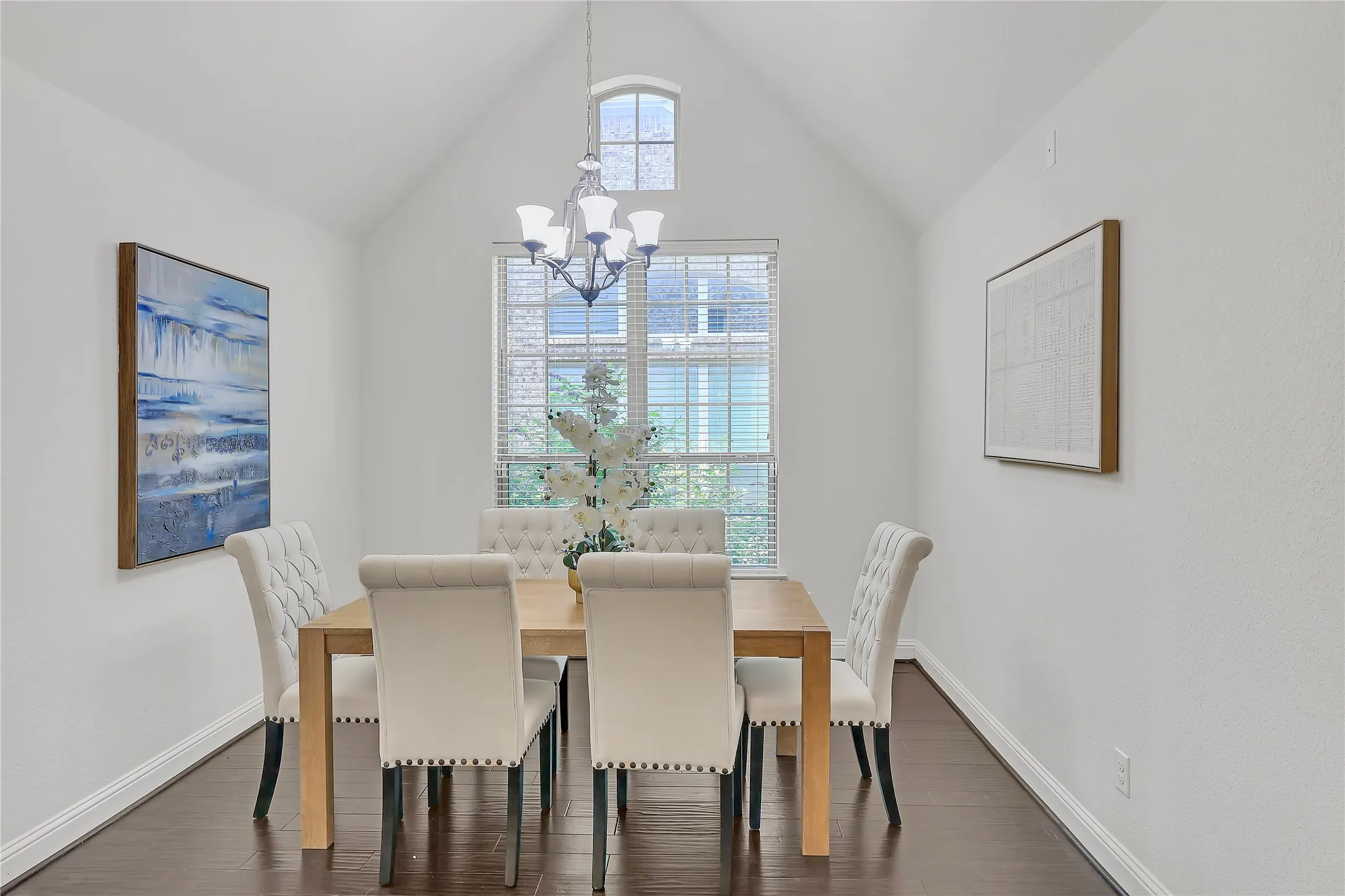 Dining room with a chandelier, dark wood finished floors, and lofted ceiling