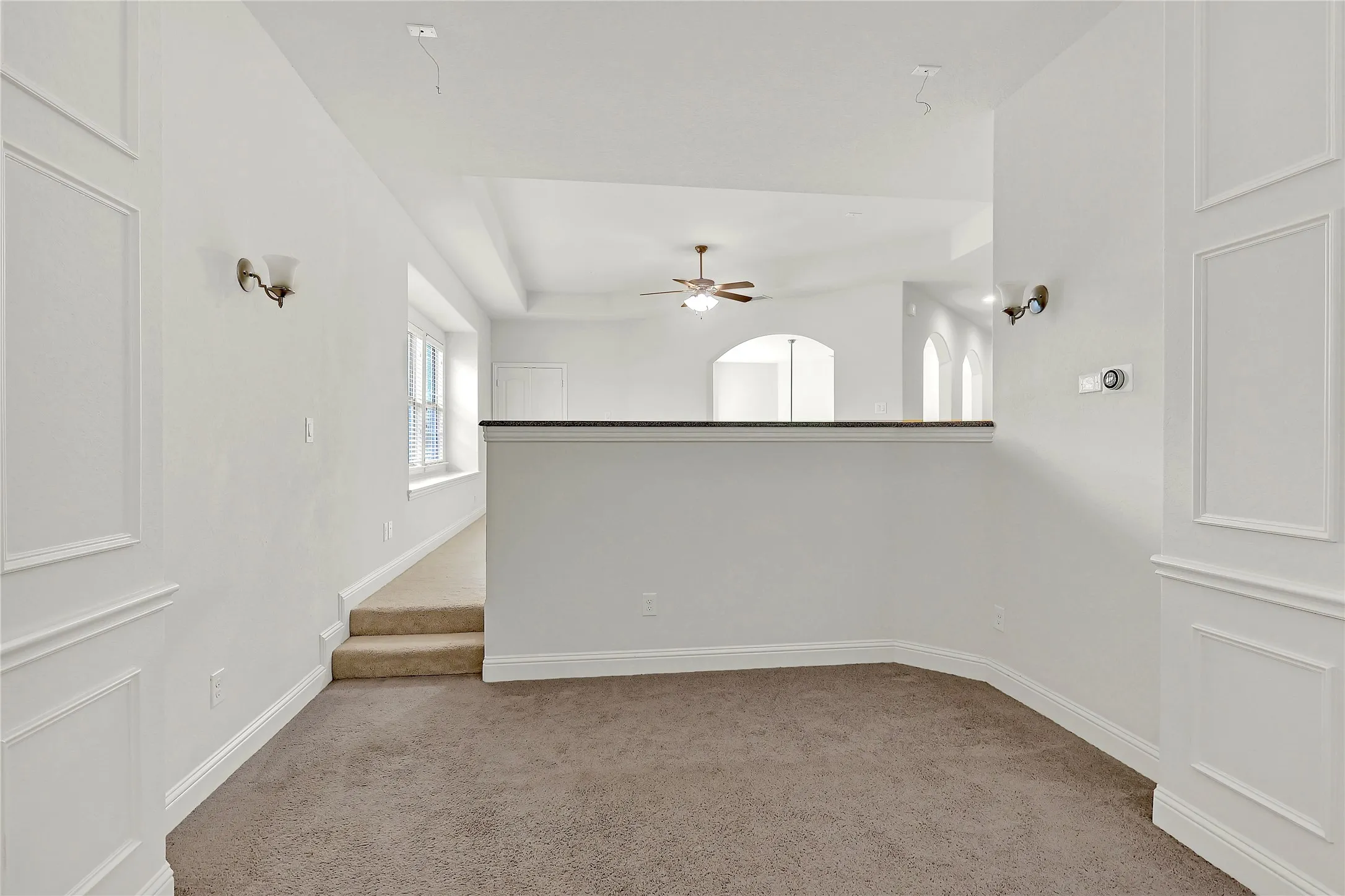 Spare room with light colored carpet and a ceiling fan