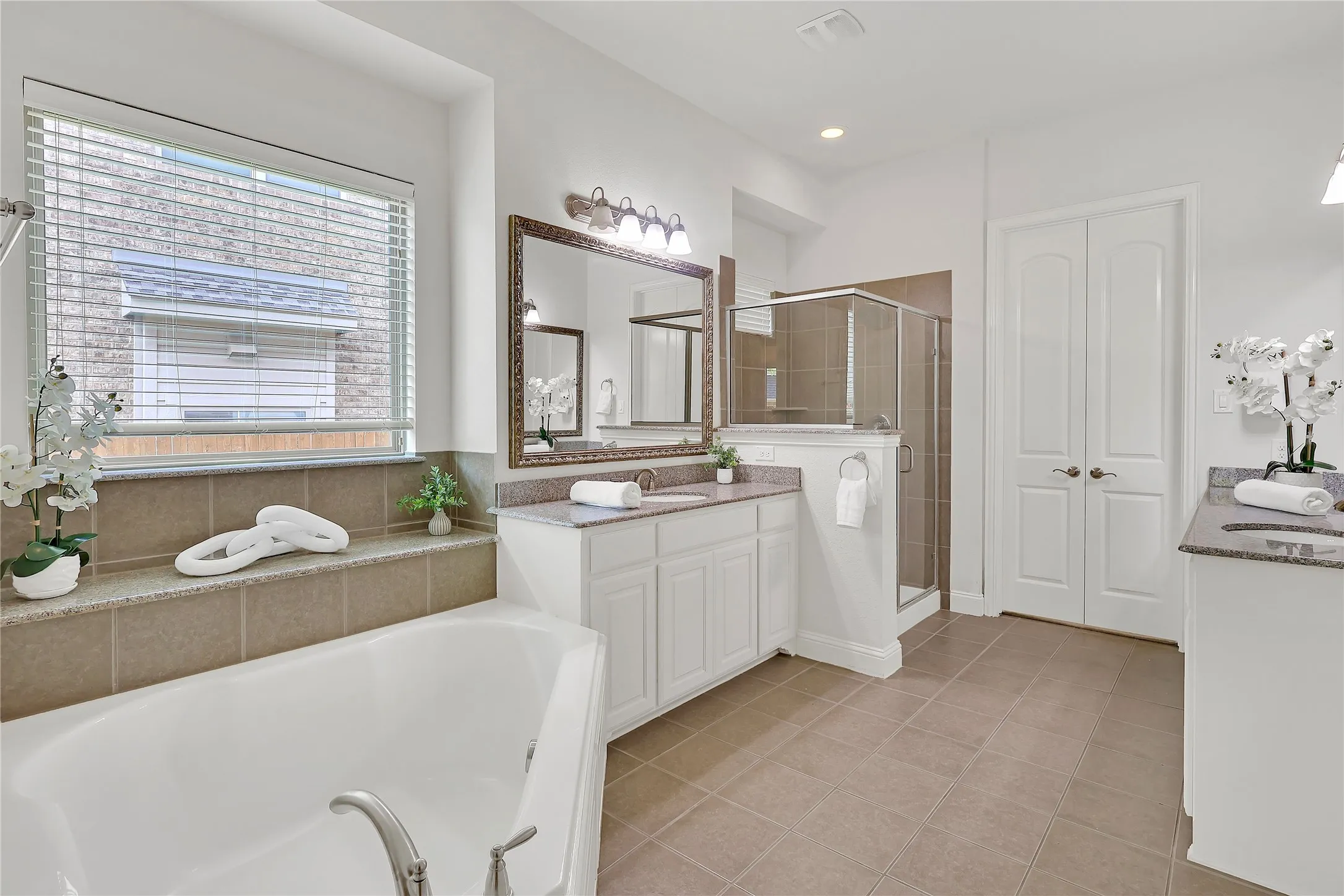 Bathroom featuring vanity, a garden tub, a shower stall, and tile patterned floors