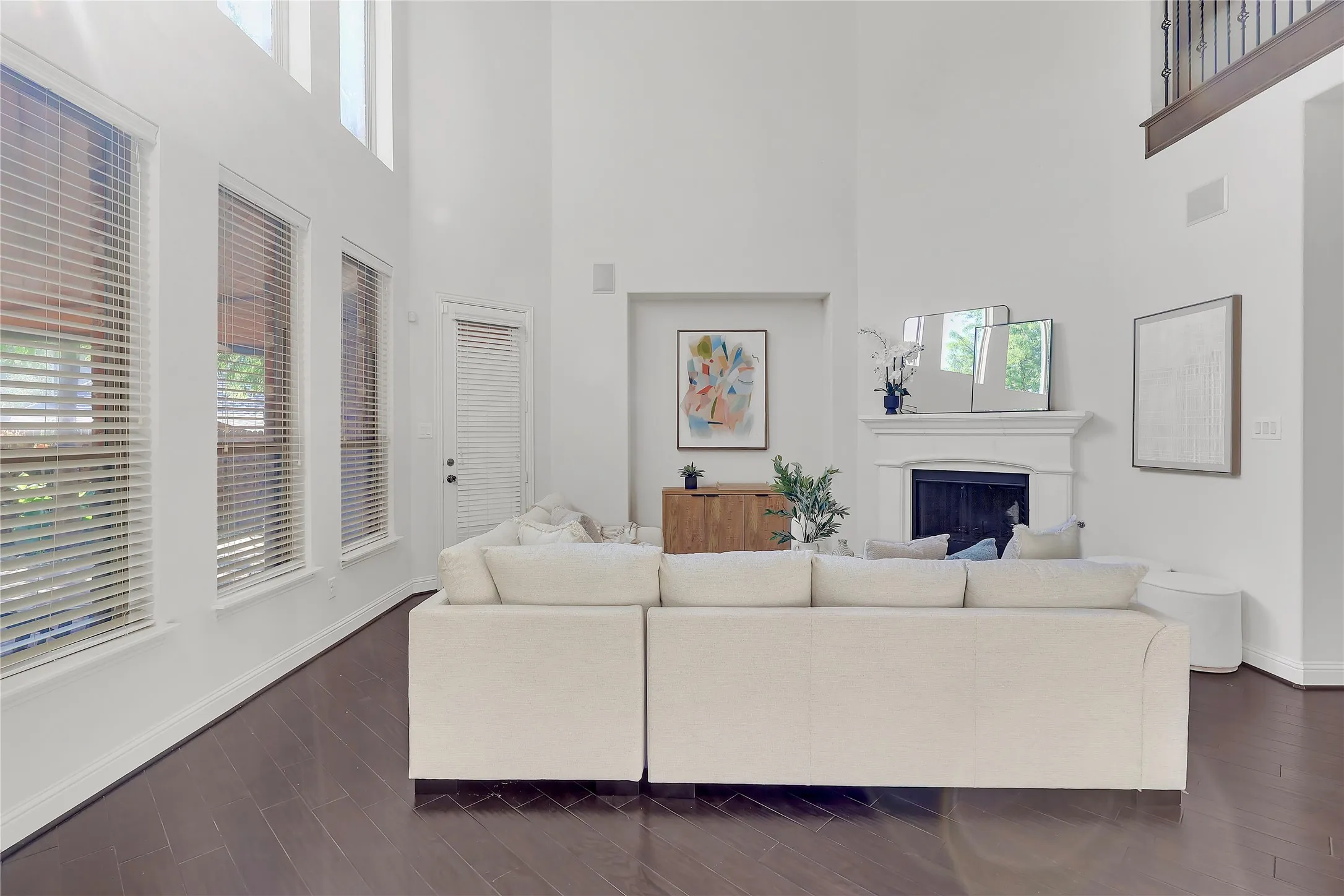 Living area with a towering ceiling, a fireplace, and dark wood-style floors