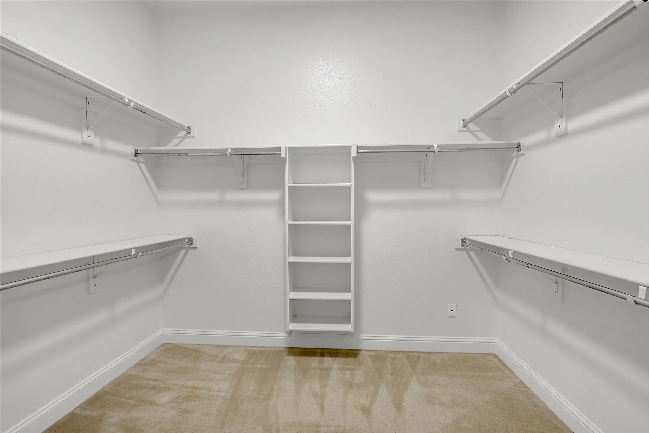Spacious closet with light colored carpet