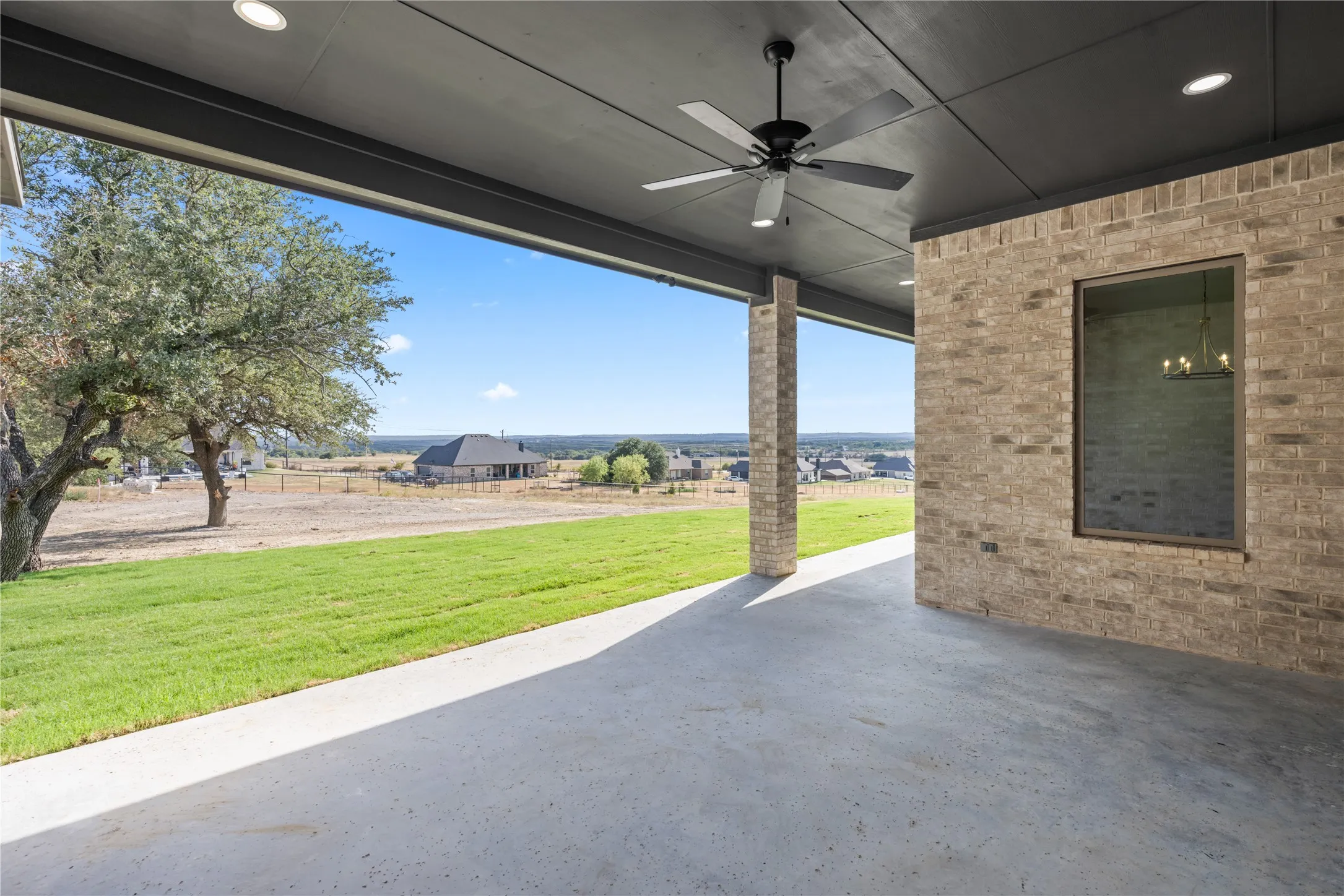 Expansive covered patio with concrete flooring, recessed lighting, and a ceiling fan