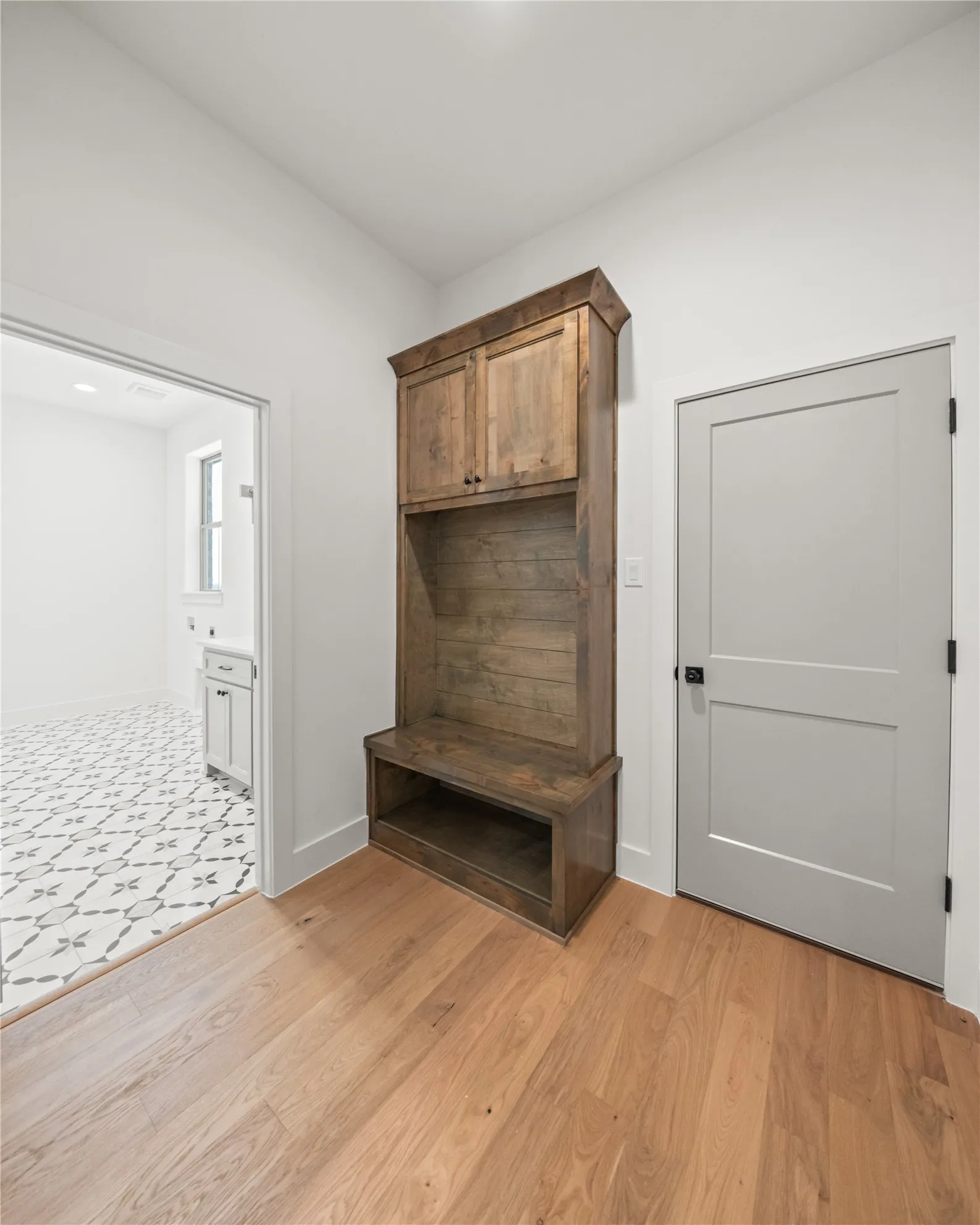 Built-in wood-finish cabinetry, solid light wood-finish flooring, and a flat-panel interior door