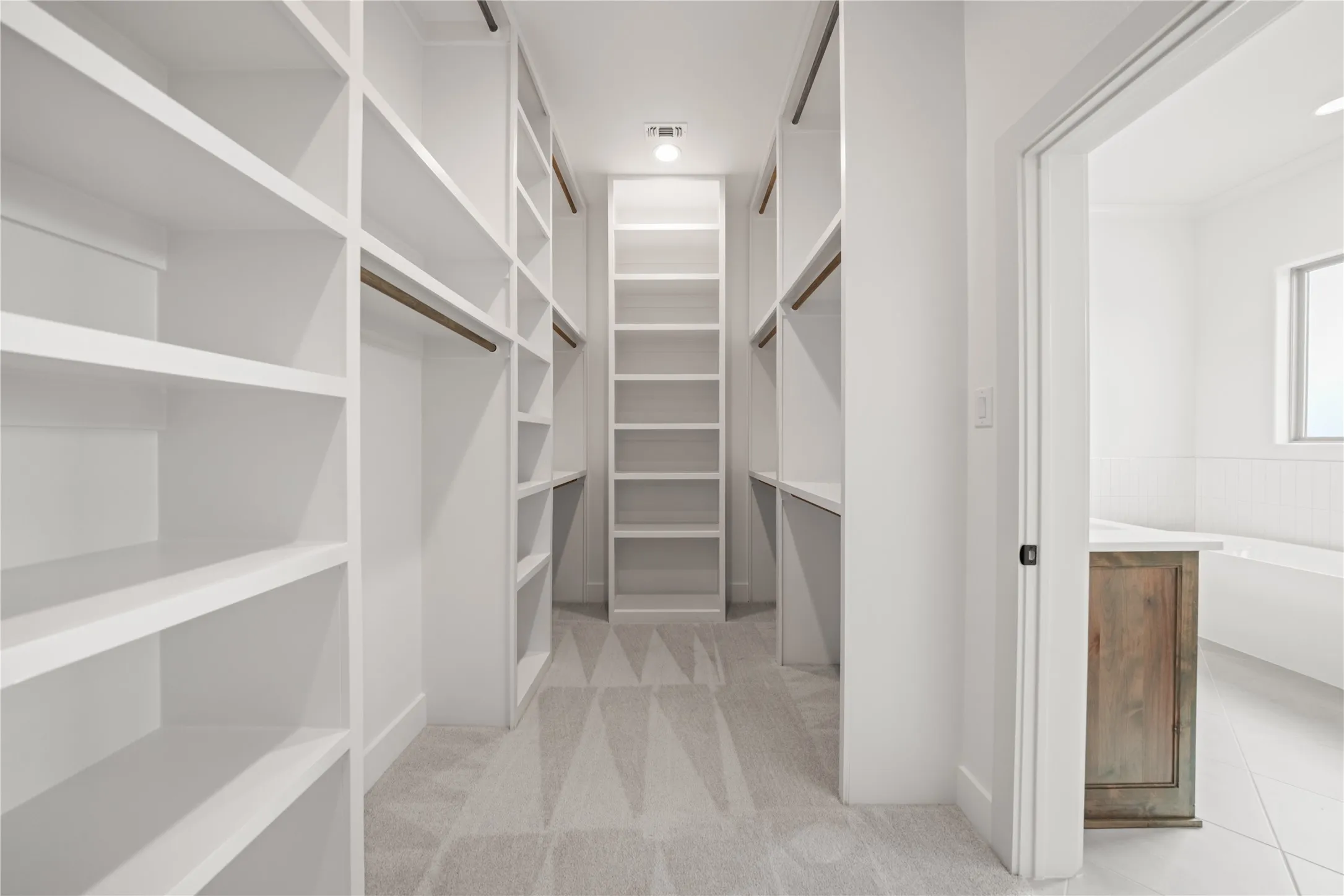 Custom built-in white shelving and hanging rods
