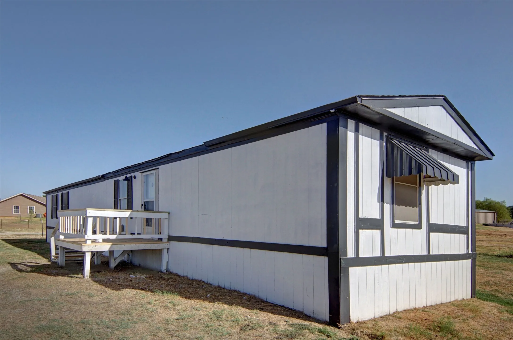 White siding exterior with dark trim accents and a gable roof