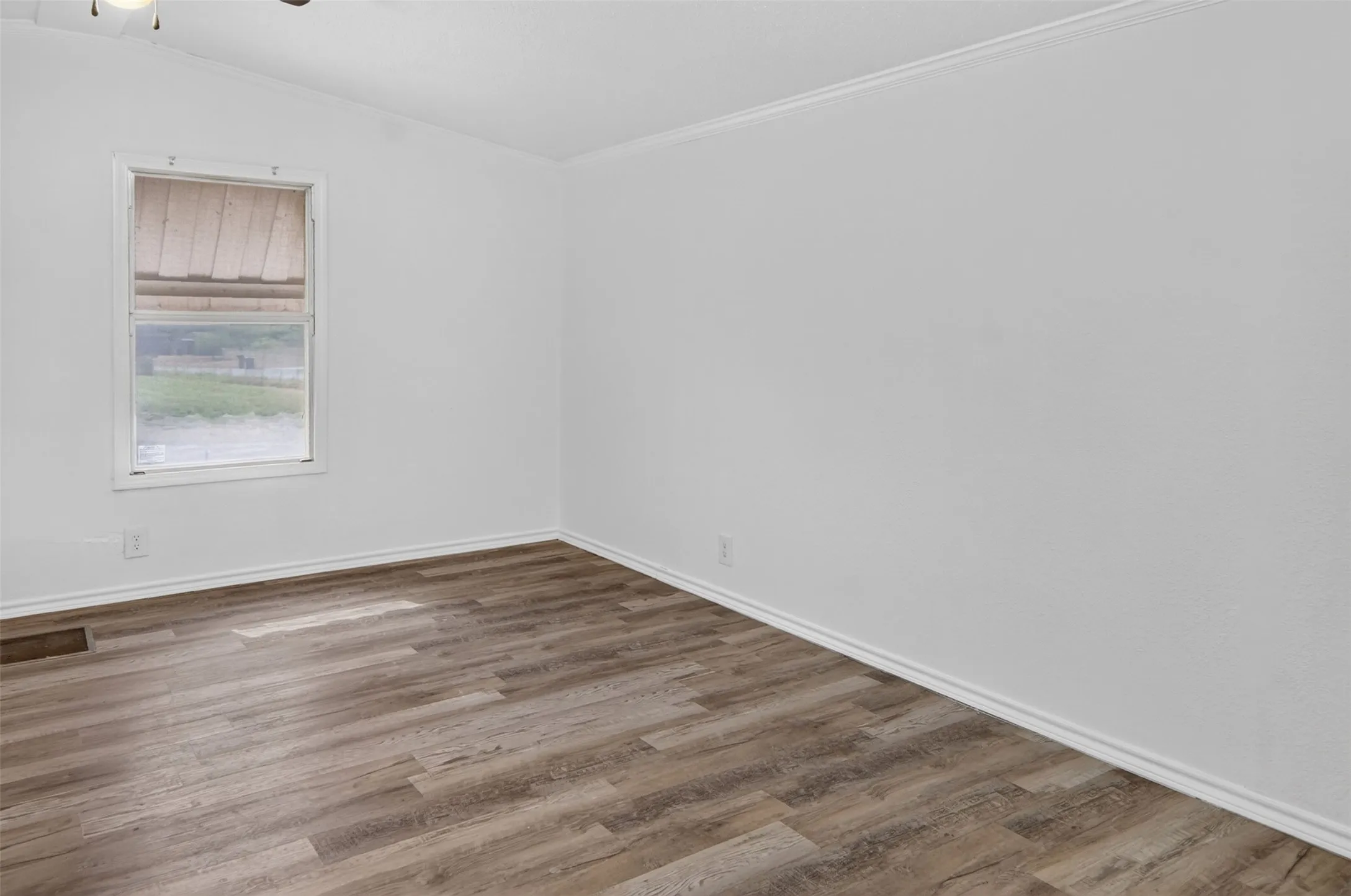 White walls, wood-finish flooring, and white trim