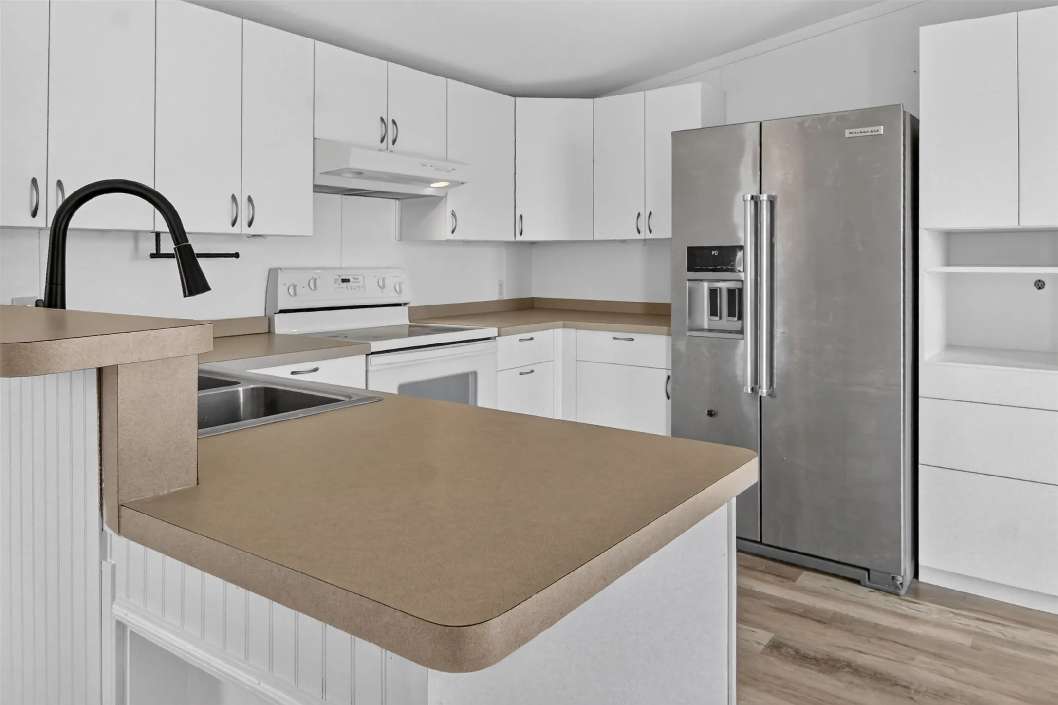 White cabinetry, stainless steel refrigerator, white electric range, double basin sink with matte black gooseneck faucet, and wood-finish flooring
