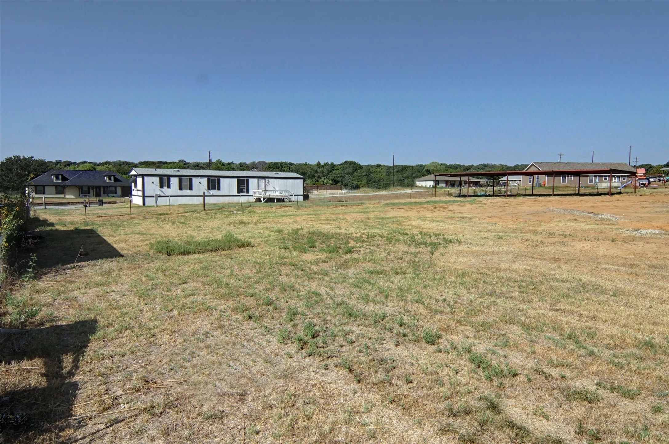 Expansive undeveloped lot with perimeter fencing