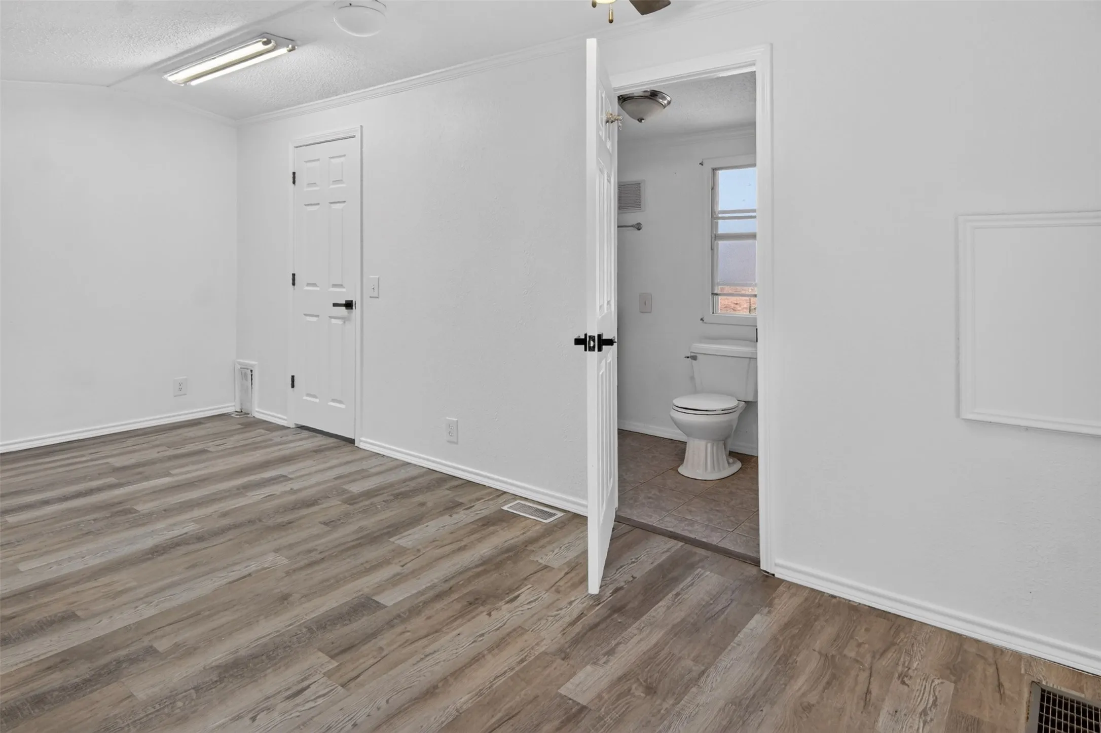 Wood-finish flooring throughout the main room with white walls and trim