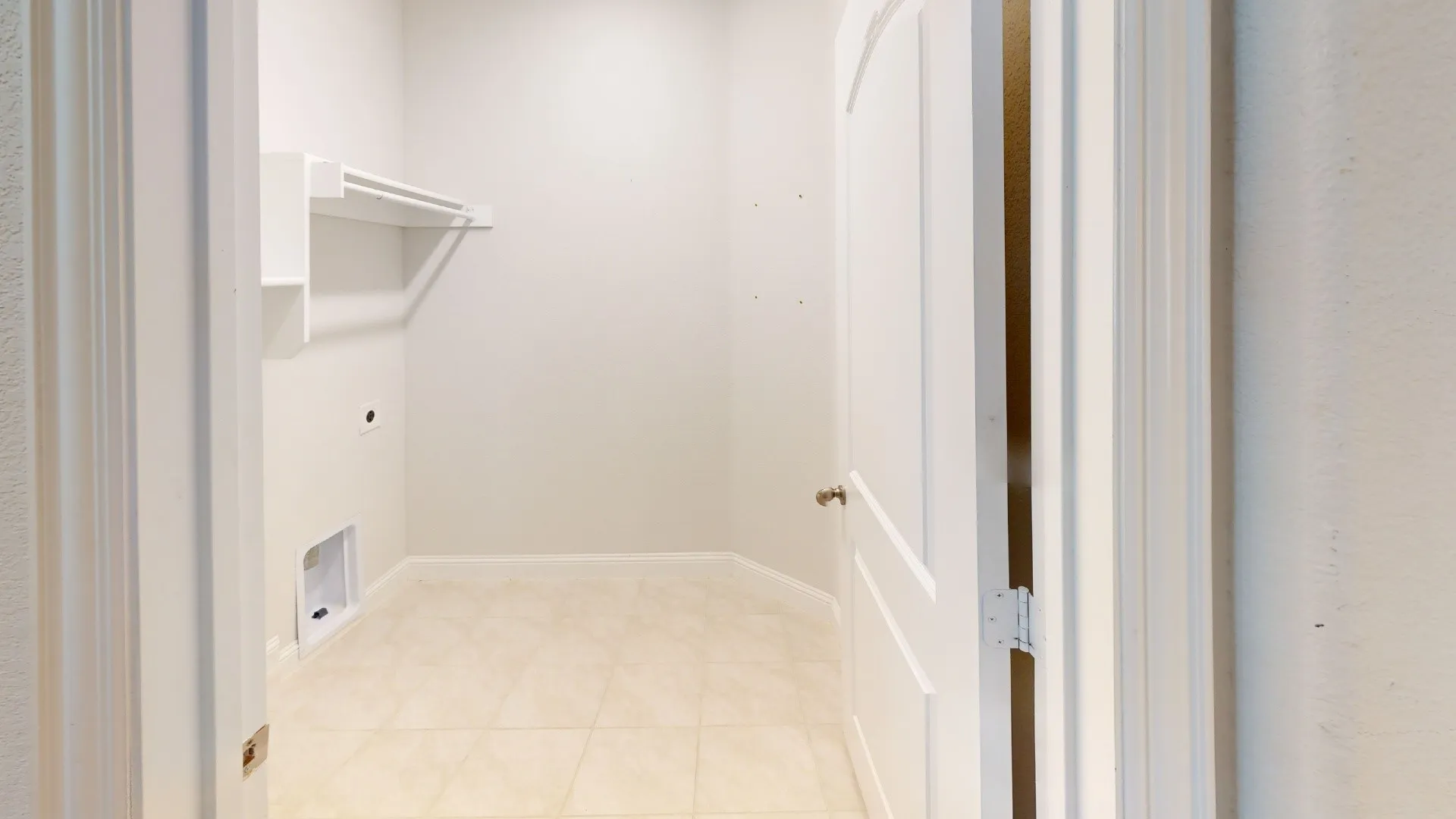 Tile flooring, built-in shelving, and a hanging rod