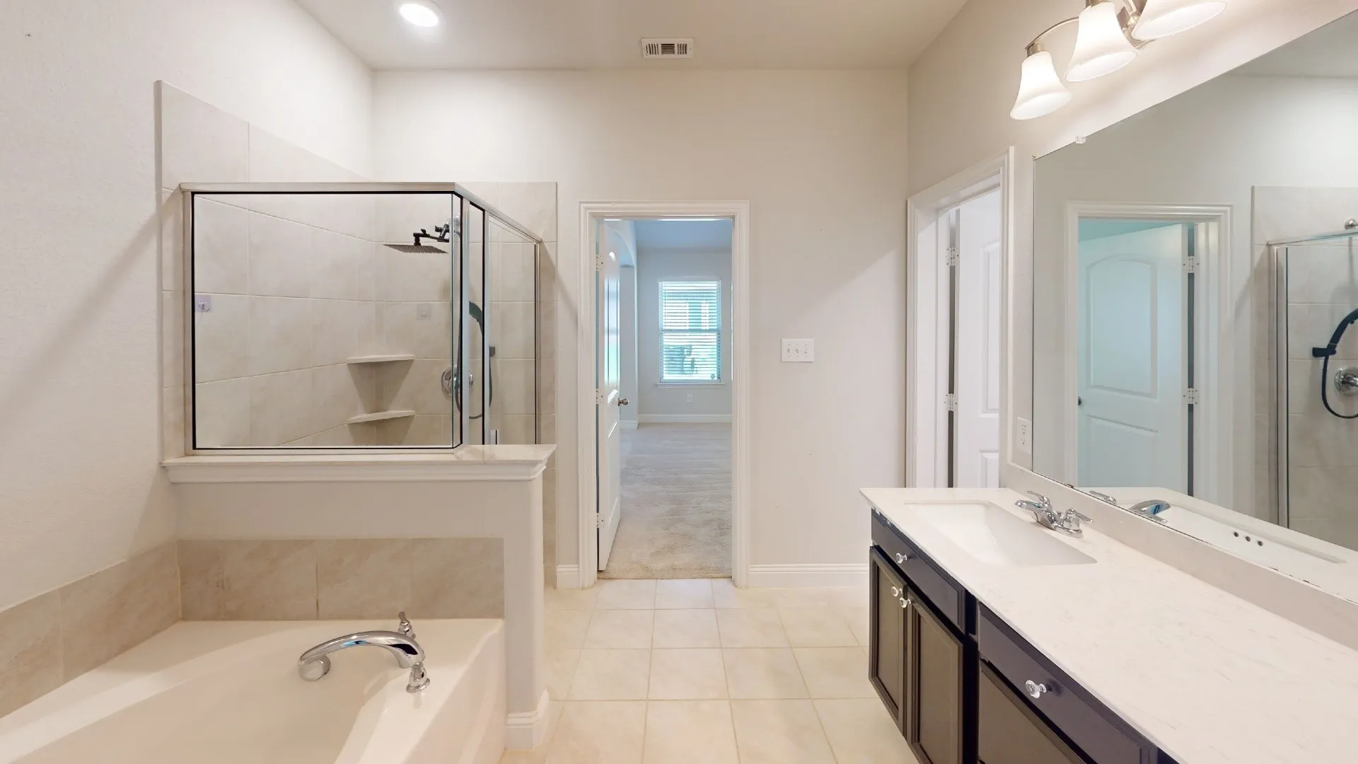 Dual vanity with integrated sinks, a large mirror, and a wall-mounted light fixture