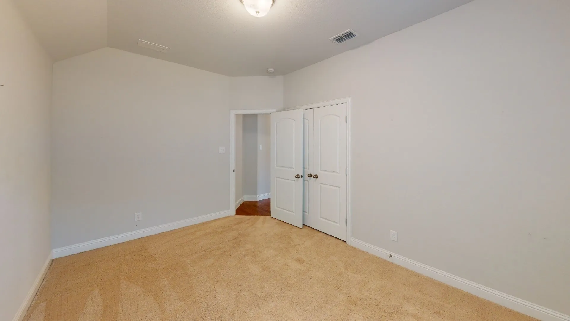 Neutral tone wall paint, vaulted ceiling, recessed lighting, and carpeted flooring