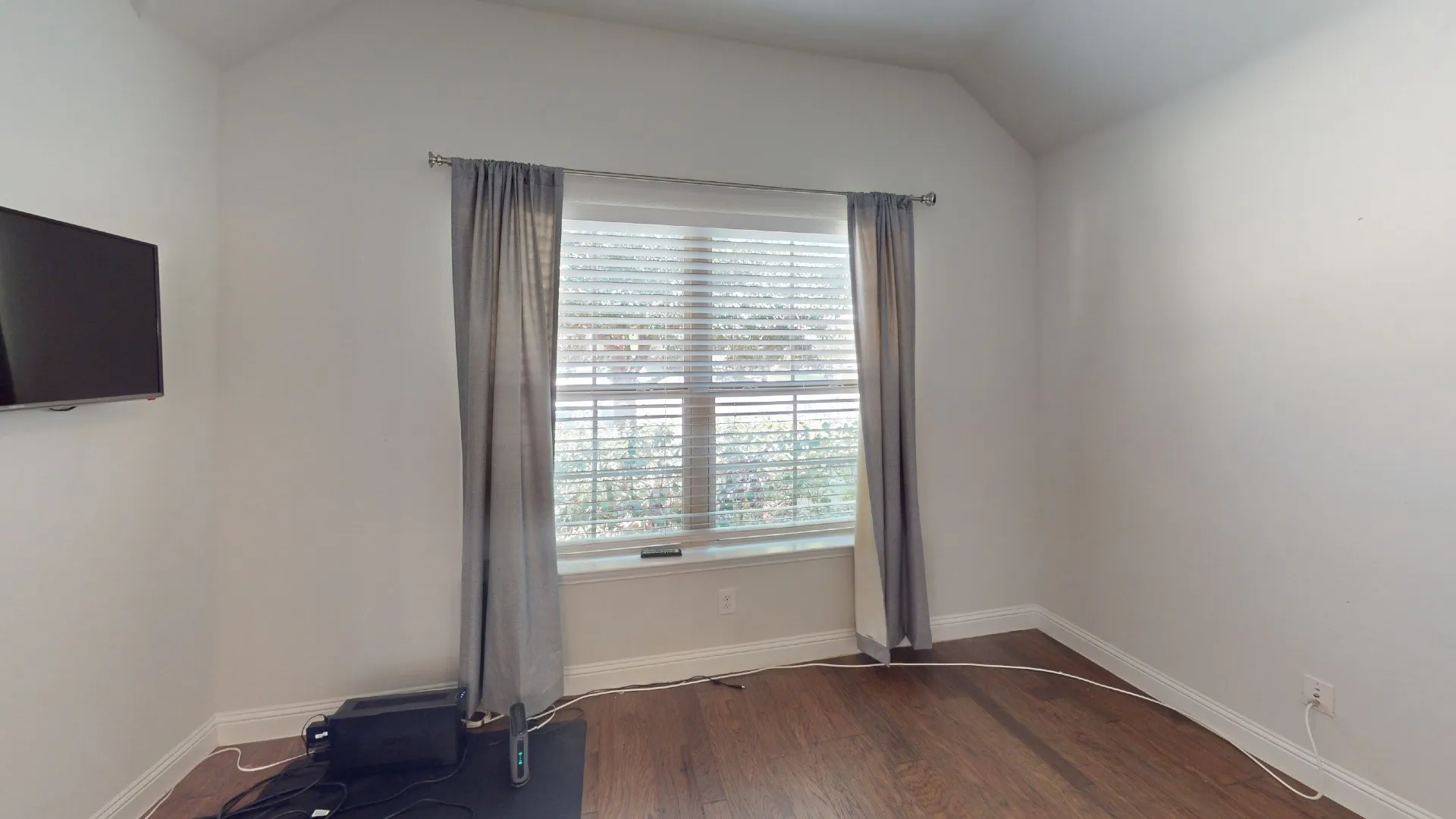 Vaulted ceiling accentuates the spacious room with wood-finish flooring