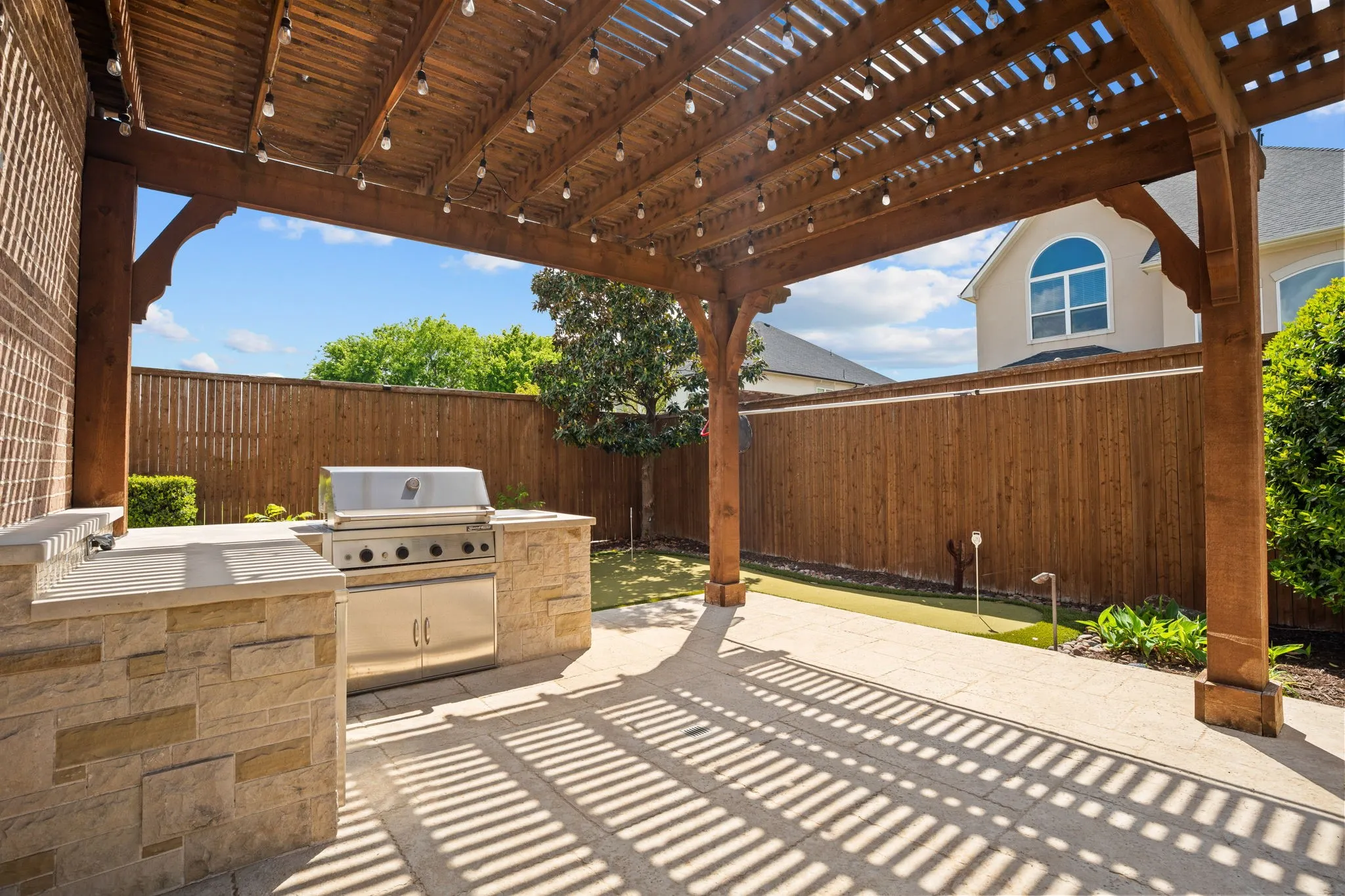 Dine al fresco or serve up a sumptuous barbecue under the arbor covered patio. Built-in grill & storage for your grilling tools. Note the rear treeline creating privacy in your backyard!