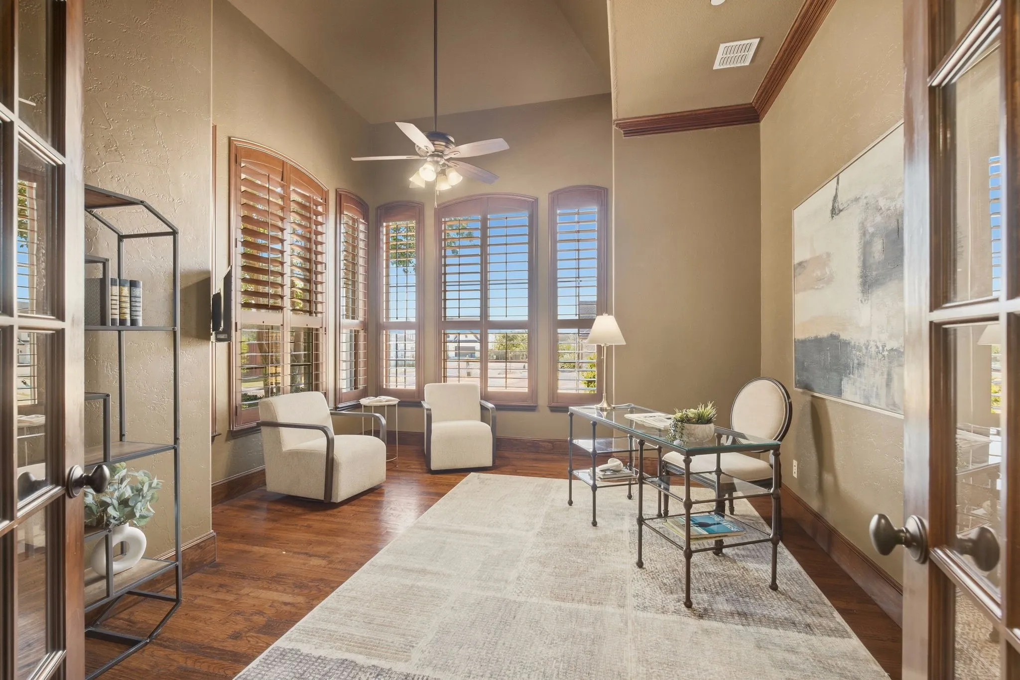 Handsome study off the foyer offers privacy for those who work from home. Another vaulted ceiling + plantation shutters that complement the hardwoods.