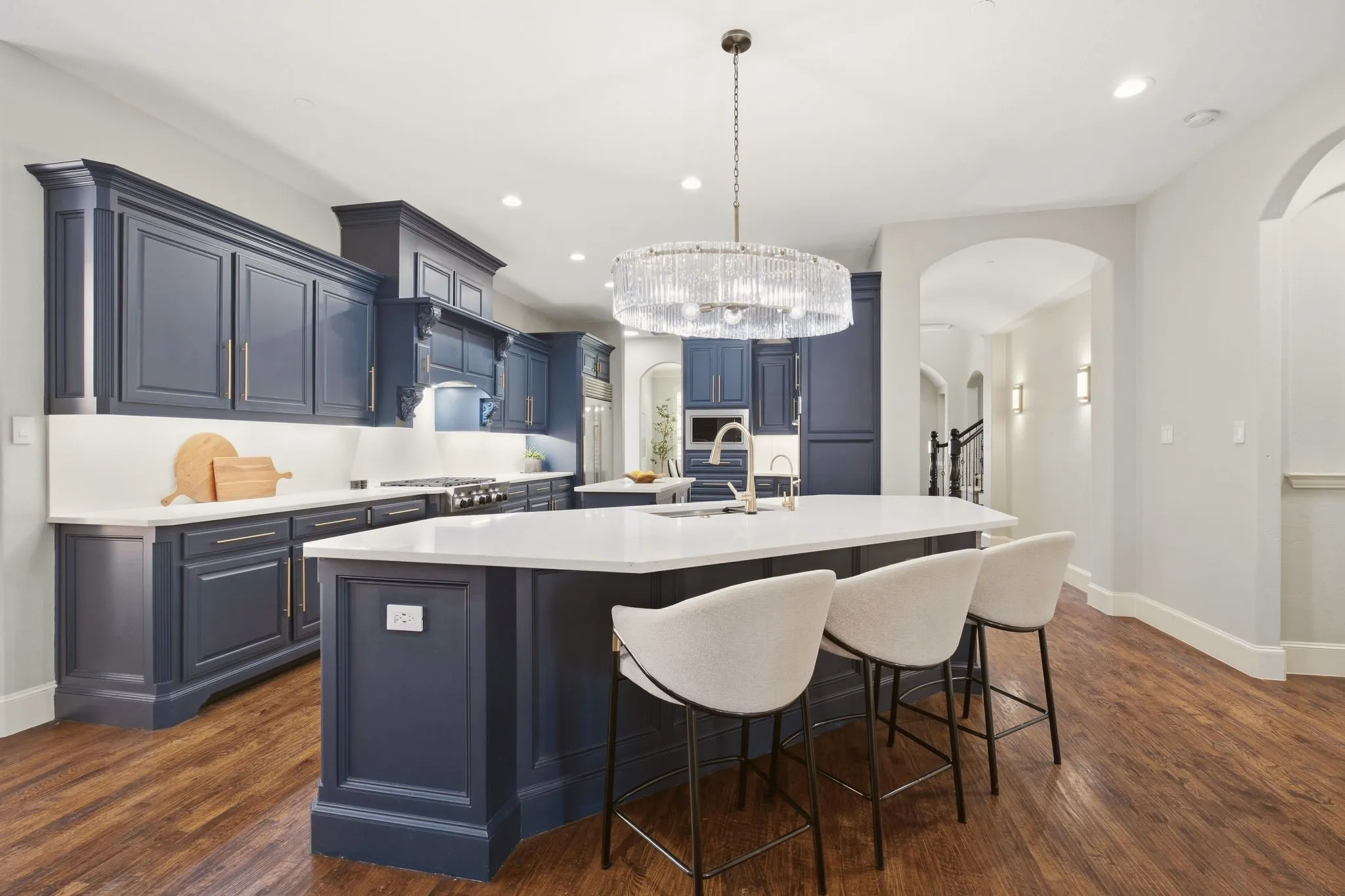 Designed for both everyday living & entertaining, you'll love this casual bar for morning coffee or informal meals. A fresh, oval pendant over the Blanco sink & quartz countertops pairs crystal panels with gleaming light at the breakfast bar. Hallway to the right leads to the primary bedroom.