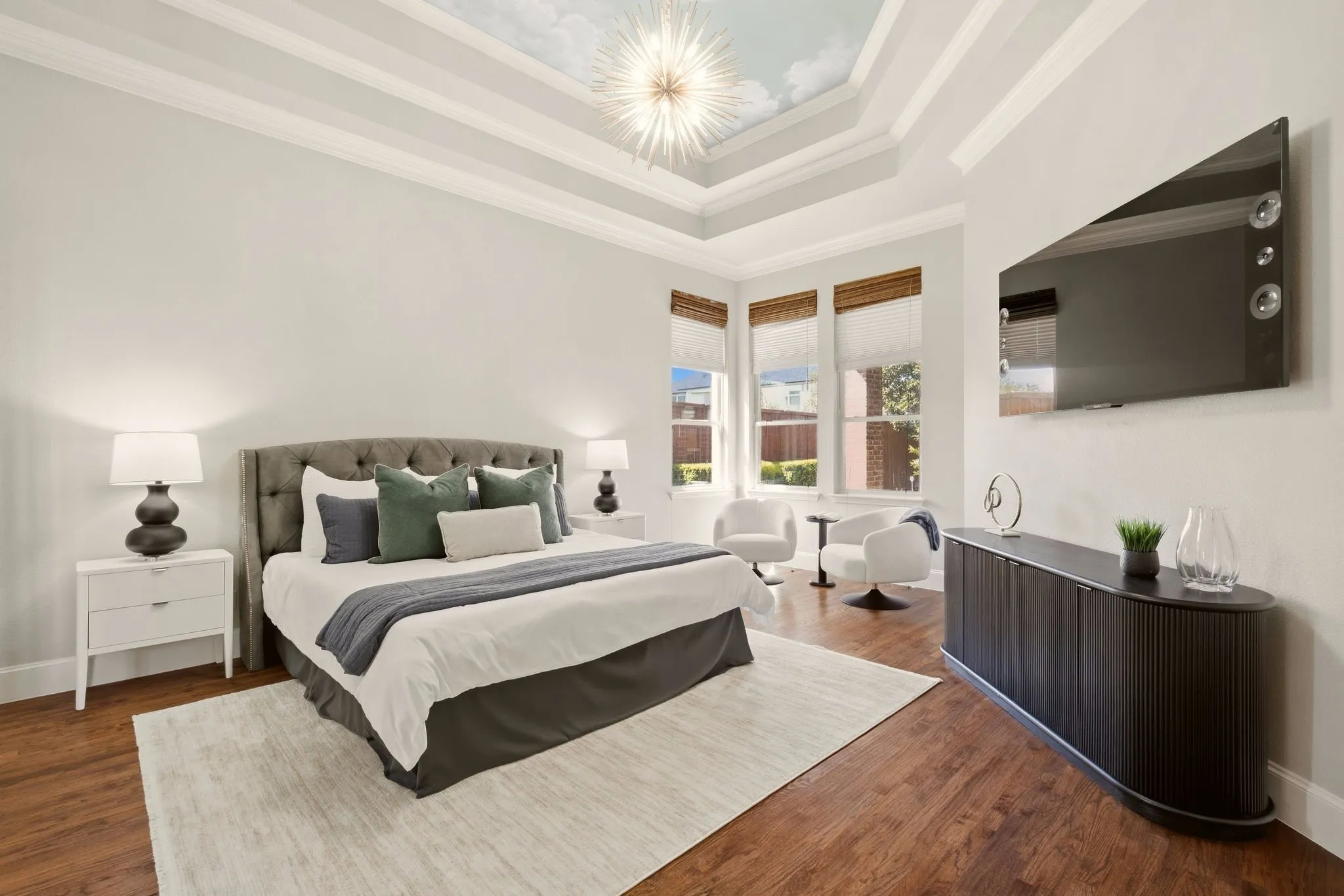Oversized primary suite is very spacious & has a cozy sitting area---a comfy spot for relaxing or reading. View the backyard fireplace & outdoor living area through the picture windows.