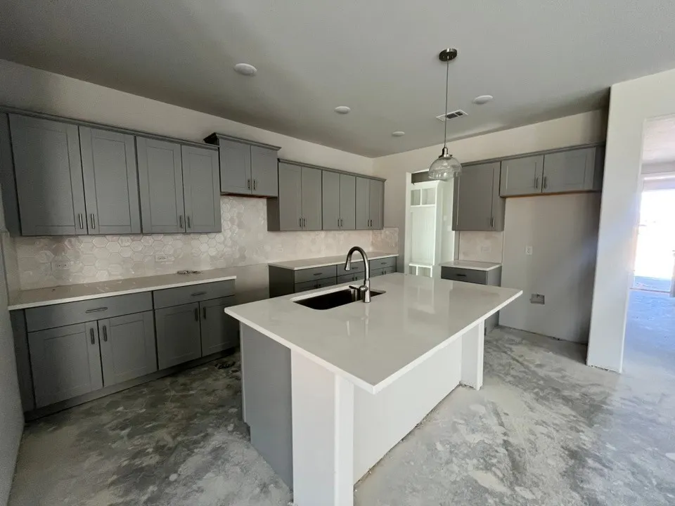 Kitchen featuring a center island, matte gray cabinetry, white countertops, and a hexagonal tile backsplash